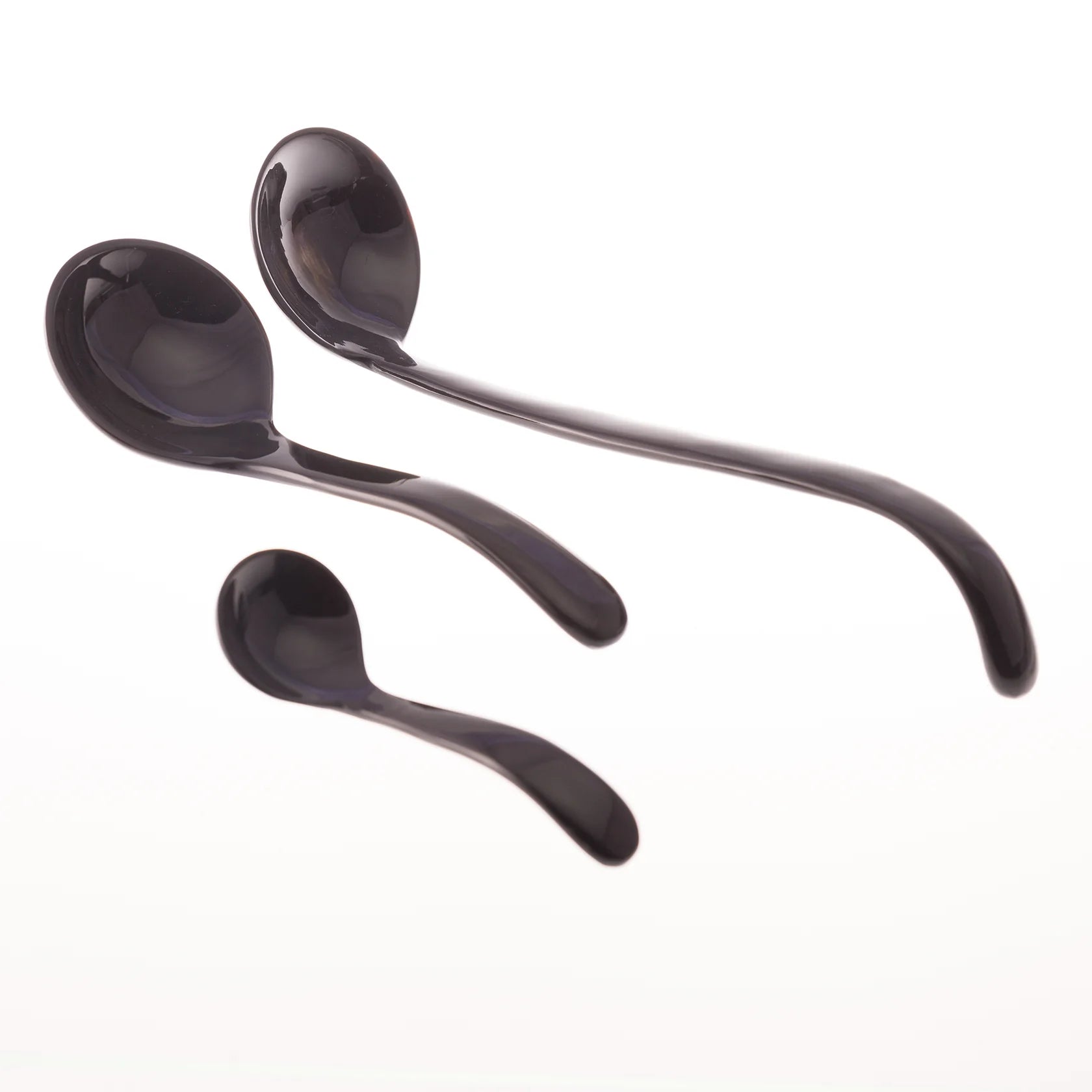 Three dark-colored serving spoons of varying sizes, shown against a white background.