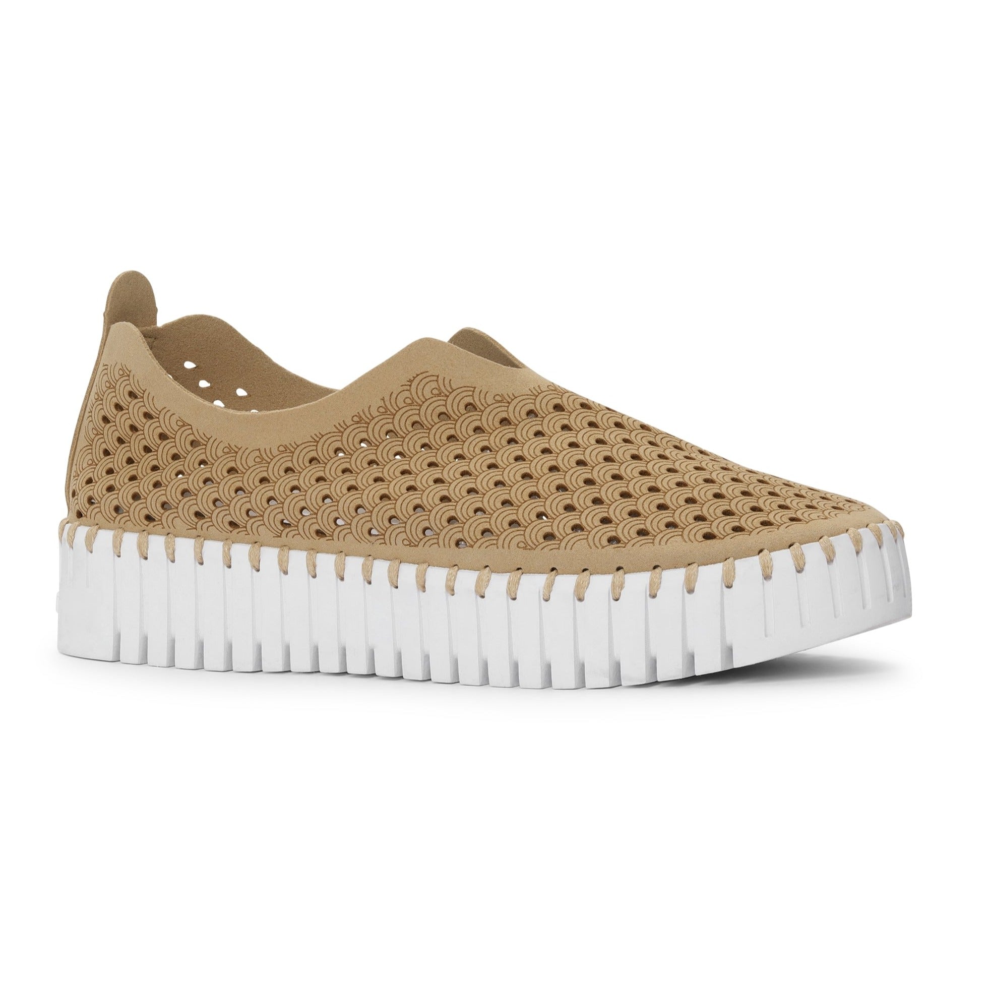 Beige slip-on shoe with a textured, perforated upper and a white, ridged sole. The upper features a repeating wave pattern.