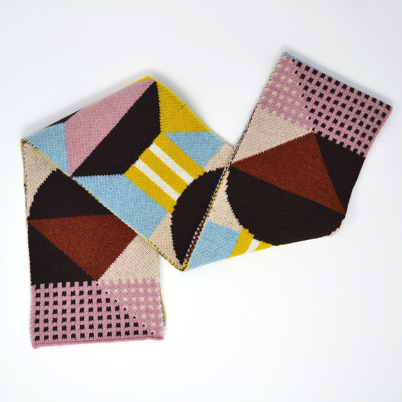 Geometric patterned knit scarf in brown, pink, beige, light blue, and mustard yellow.