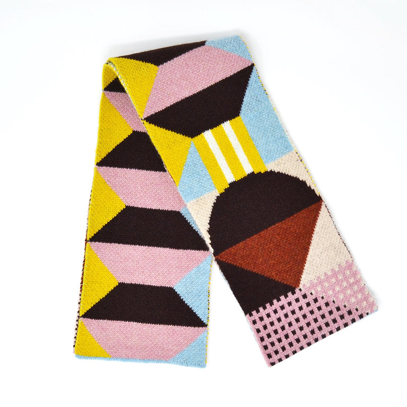 Geometric patterned knit scarf in pink, brown, yellow, and blue.