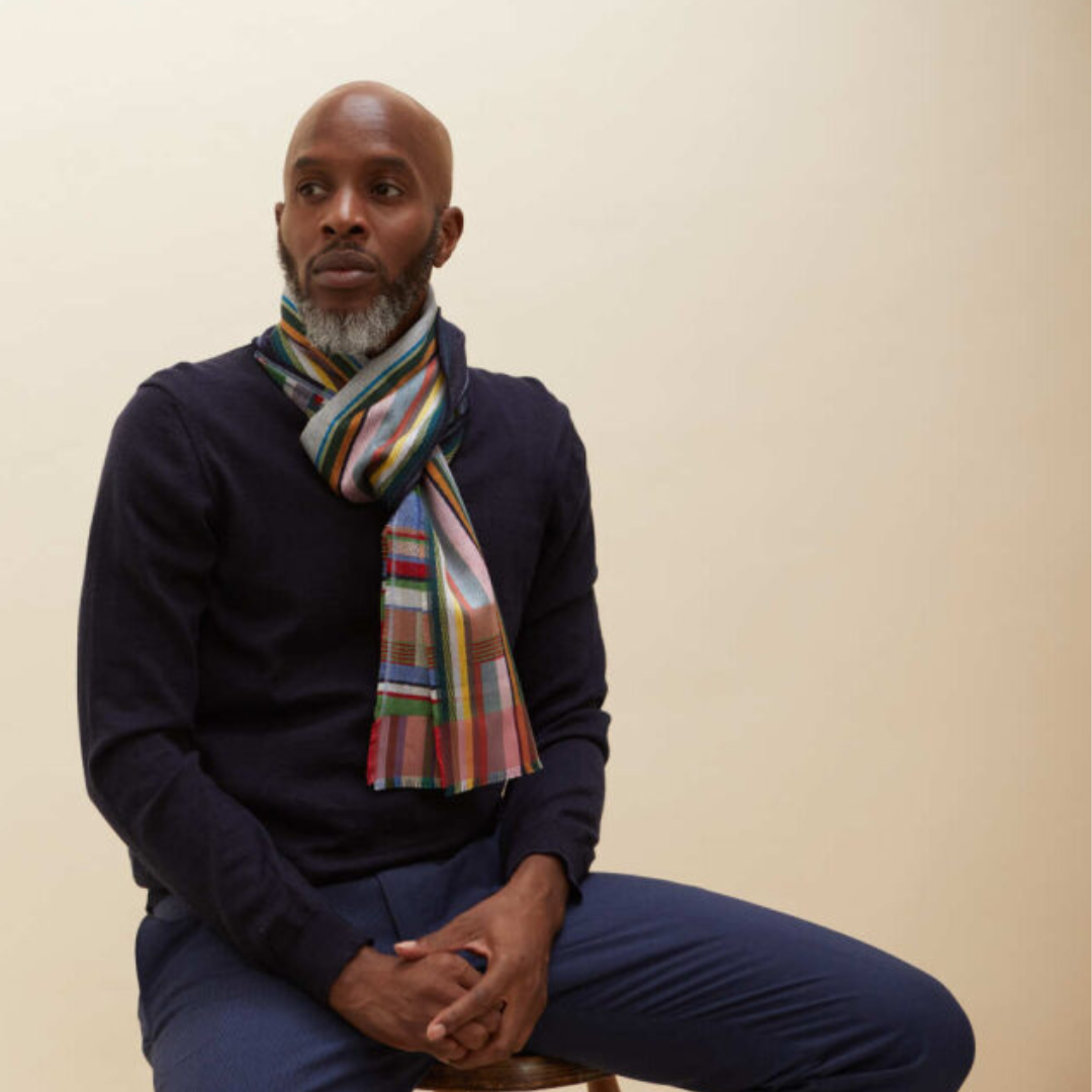 Multicolored striped wool scarf, loosely knotted around neck.