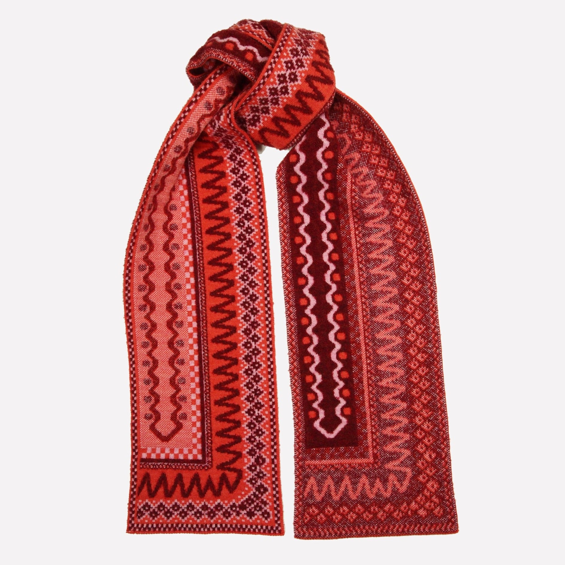 Red and burgundy patterned knit scarf with geometric designs.  The scarf is folded and knotted.