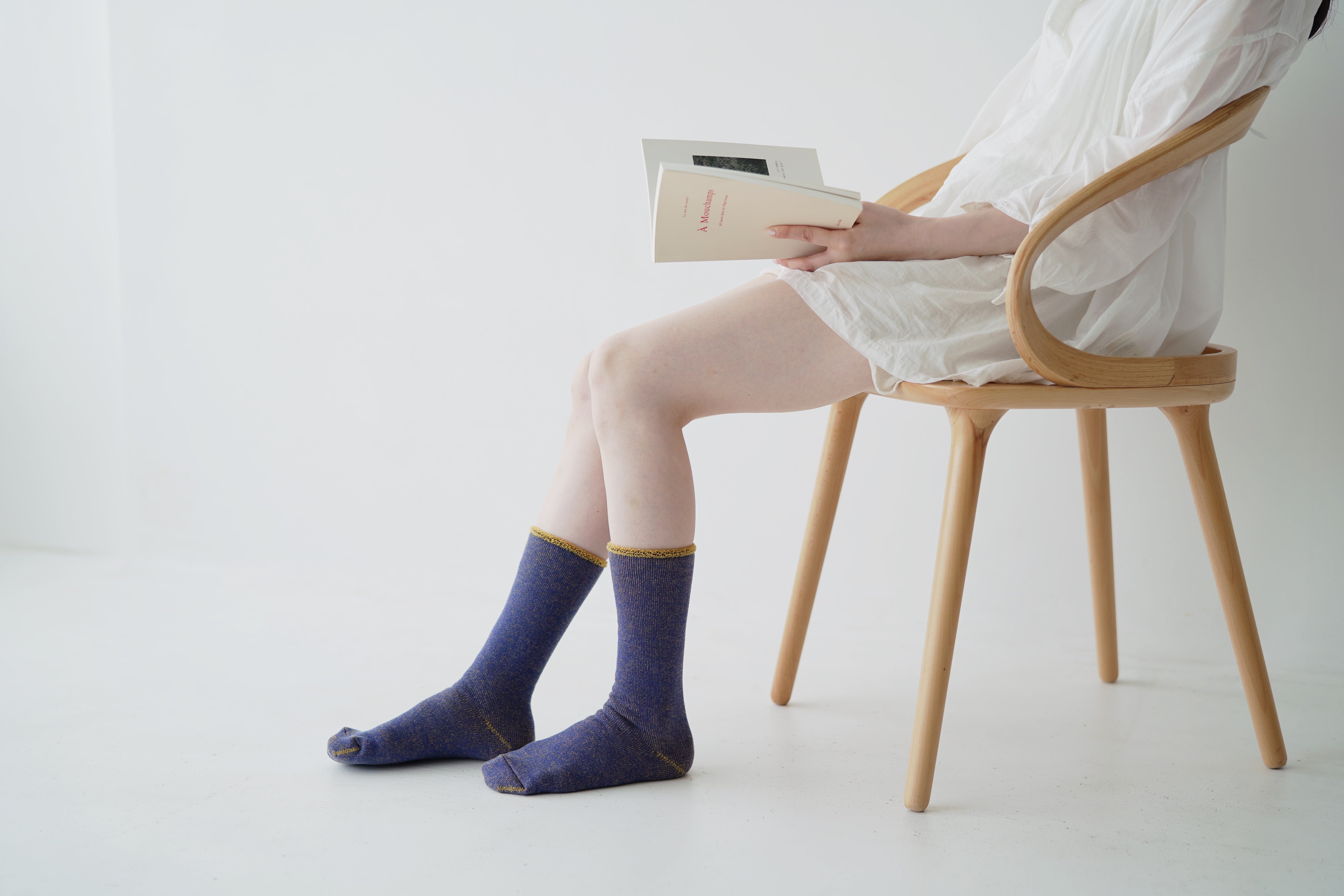 Pair of purple crew socks with gold trim, shown on a person's legs.