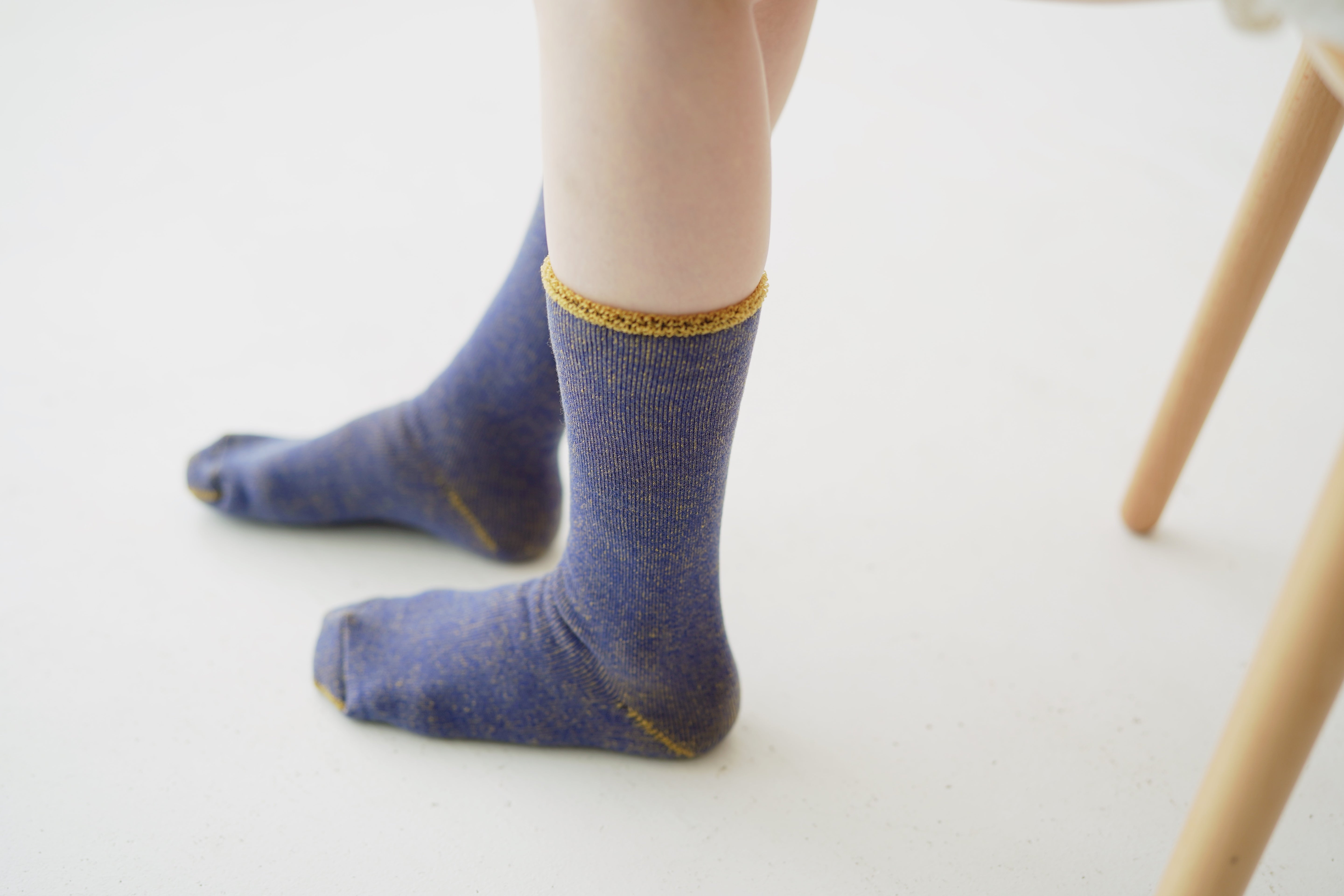 Pair of purple crew socks with gold flecks and a gold top trim.