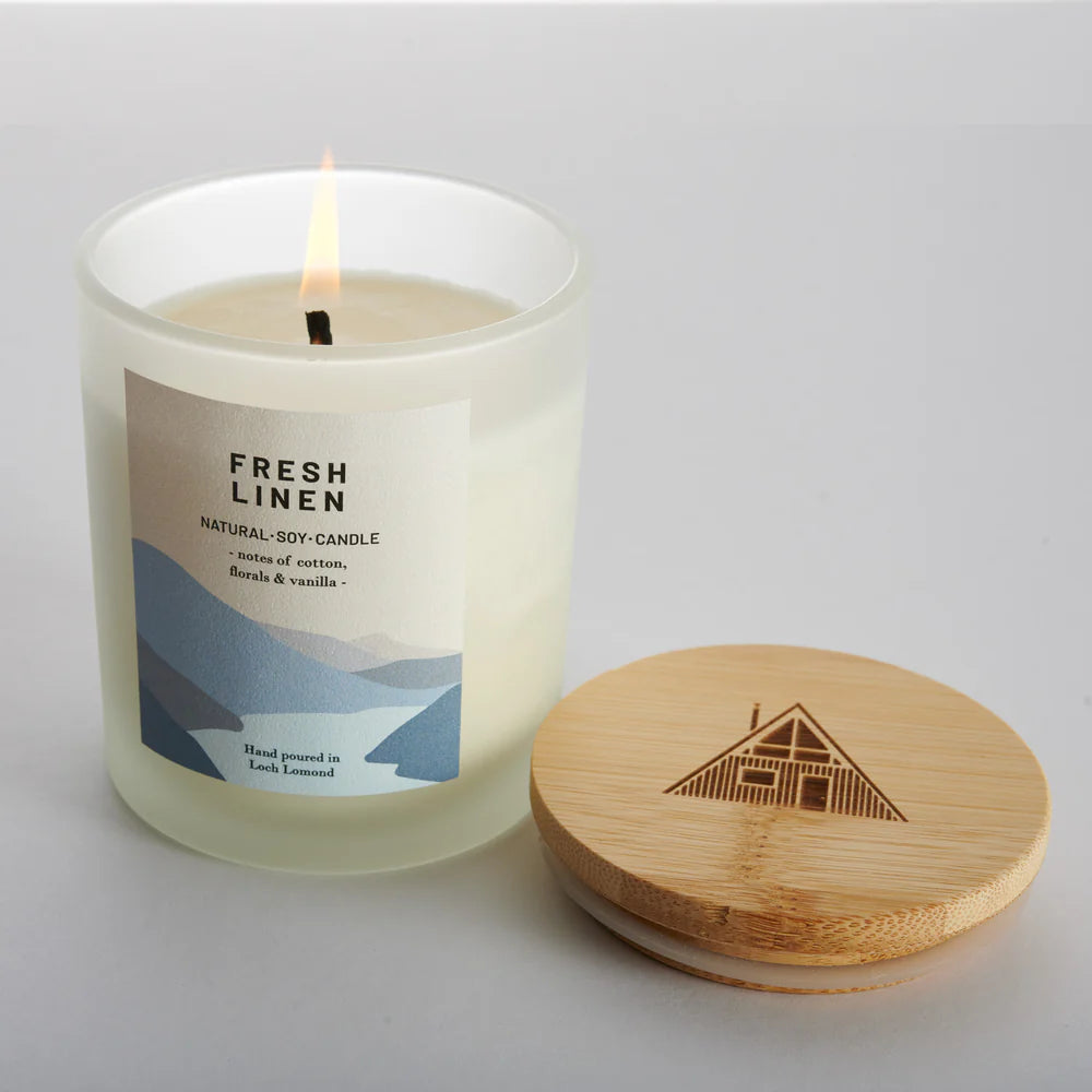 Frosted glass jar candle with "Fresh Linen" label; natural soy candle with cotton, floral & vanilla notes; bamboo lid with