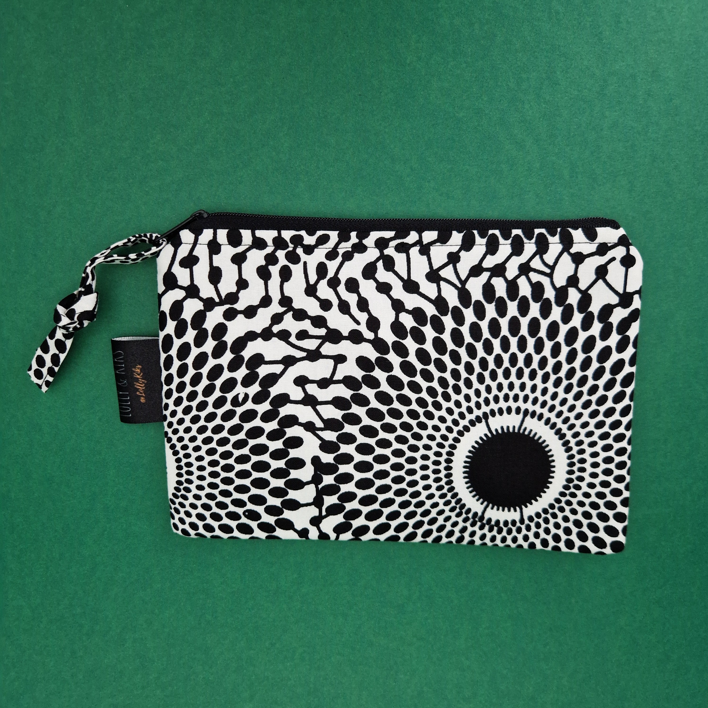 Black and white patterned zippered pouch with a fabric drawstring.