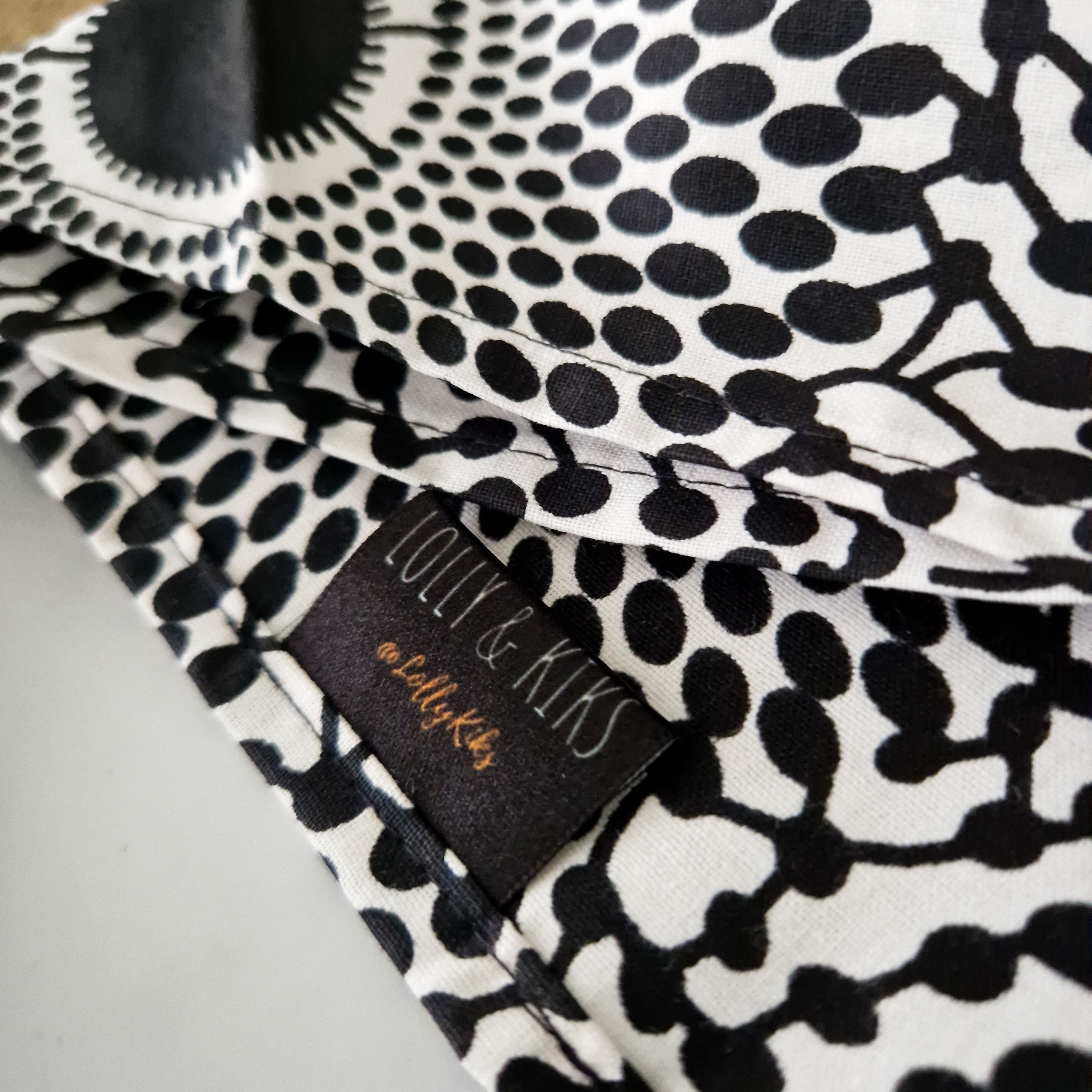 Close-up of a Lolly & Kix fabric featuring a black and white pattern of interconnected circles.