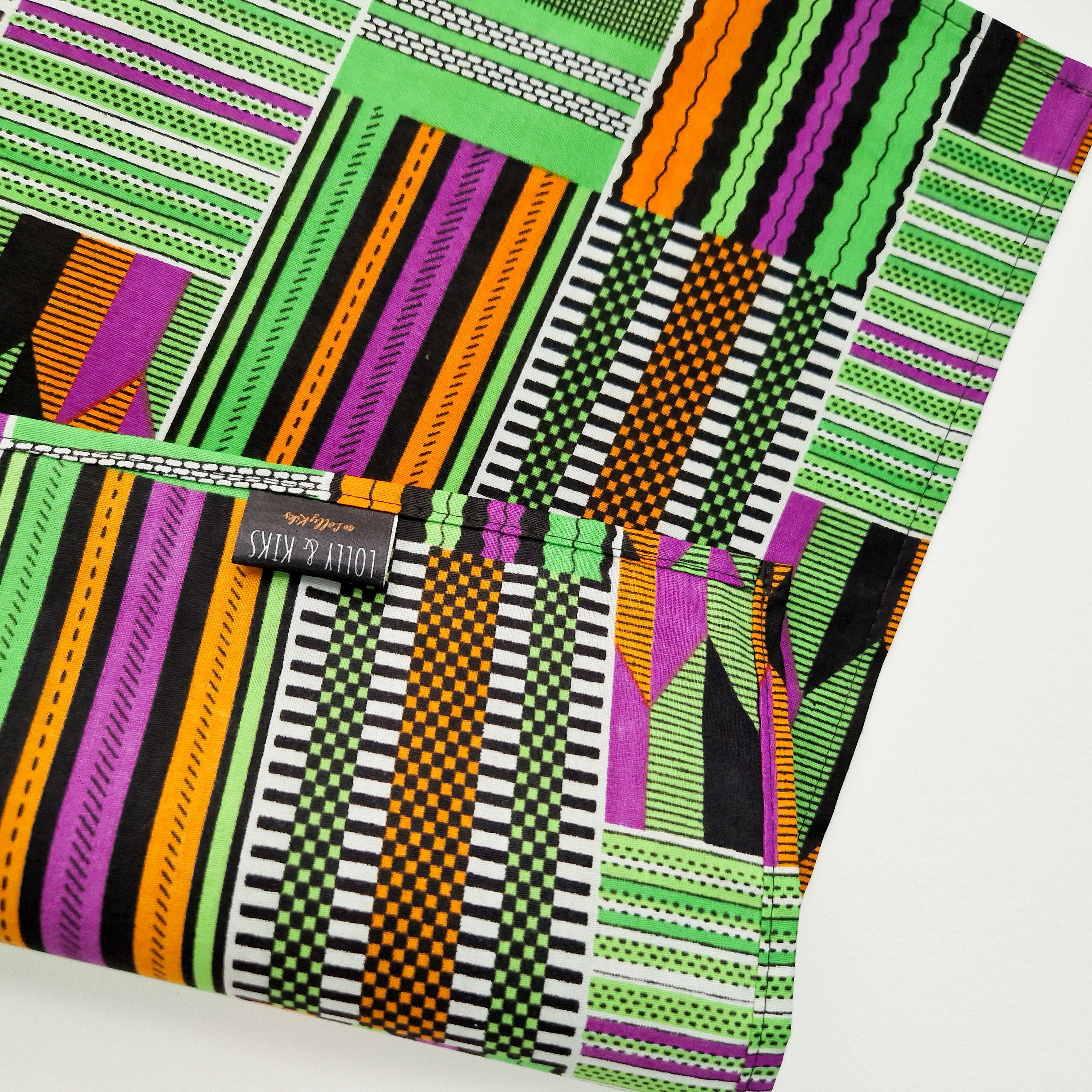 Fabric with a geometric pattern in green, purple, orange, and black.