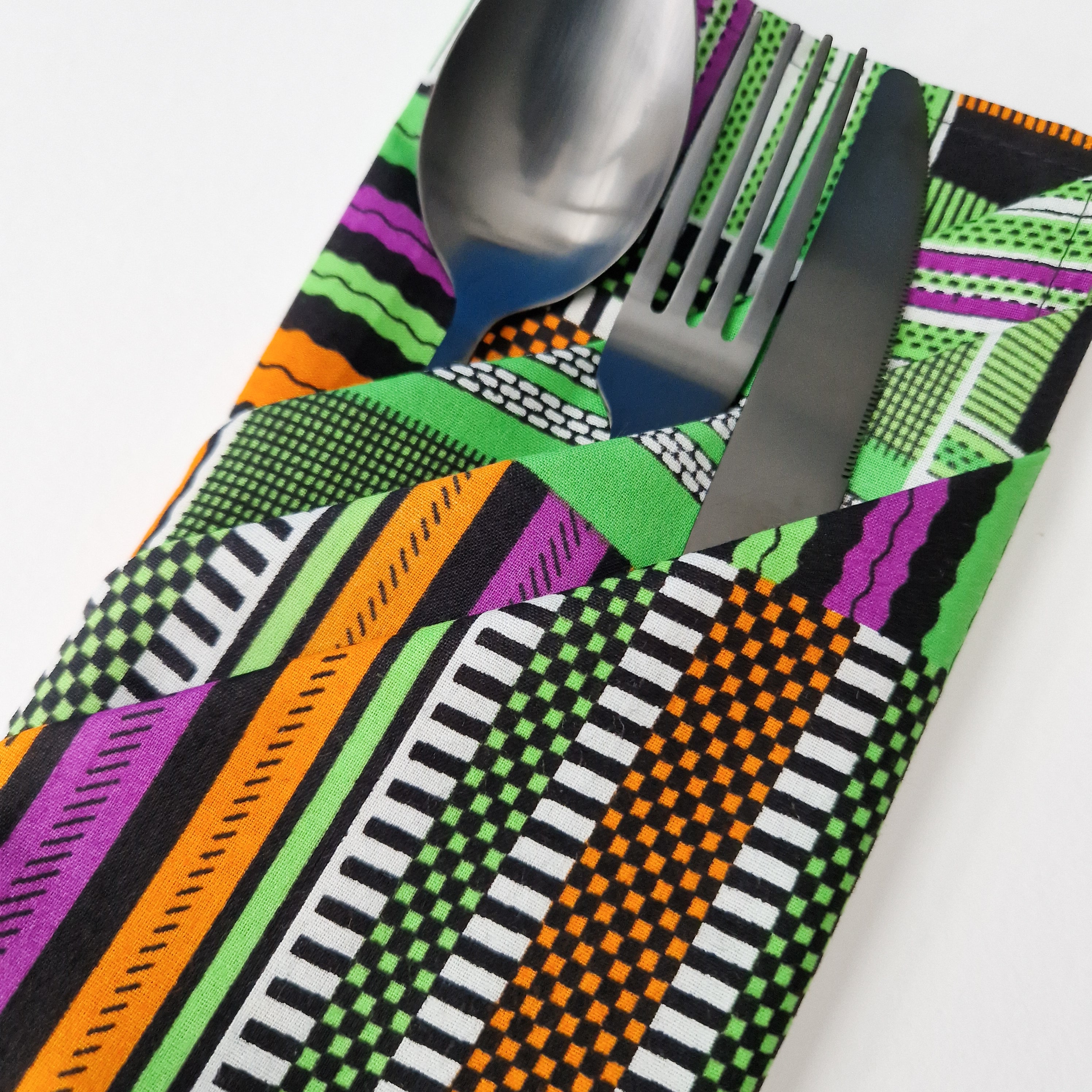 Silverware nestled in a folded fabric napkin.