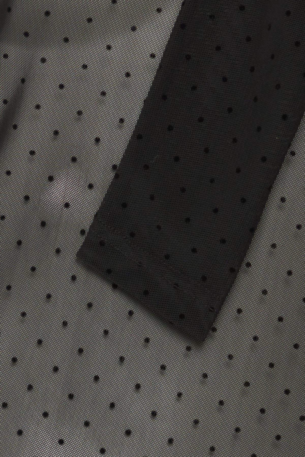 Close-up of black sheer fabric with small, evenly spaced dots.