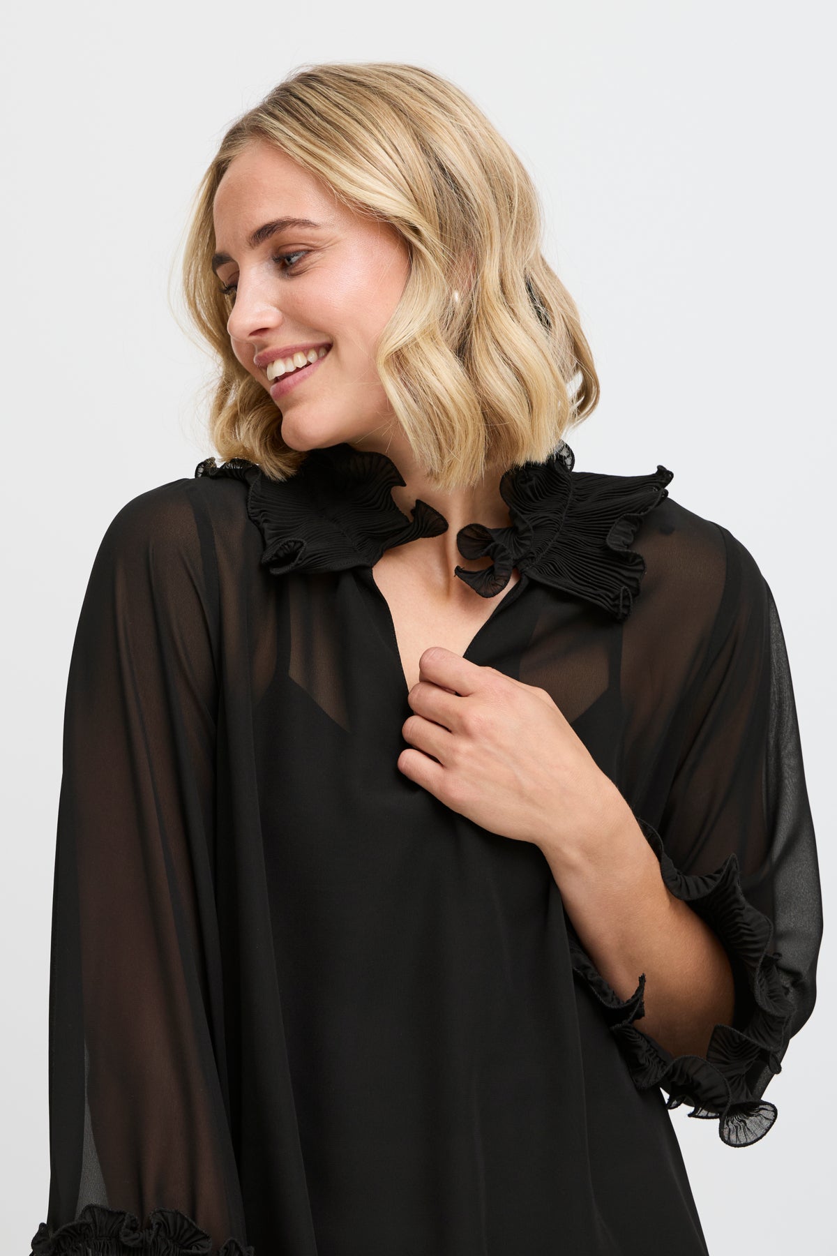 Black sheer blouse with pleated ruffle collar and cuffs.  Three-quarter sleeves.
