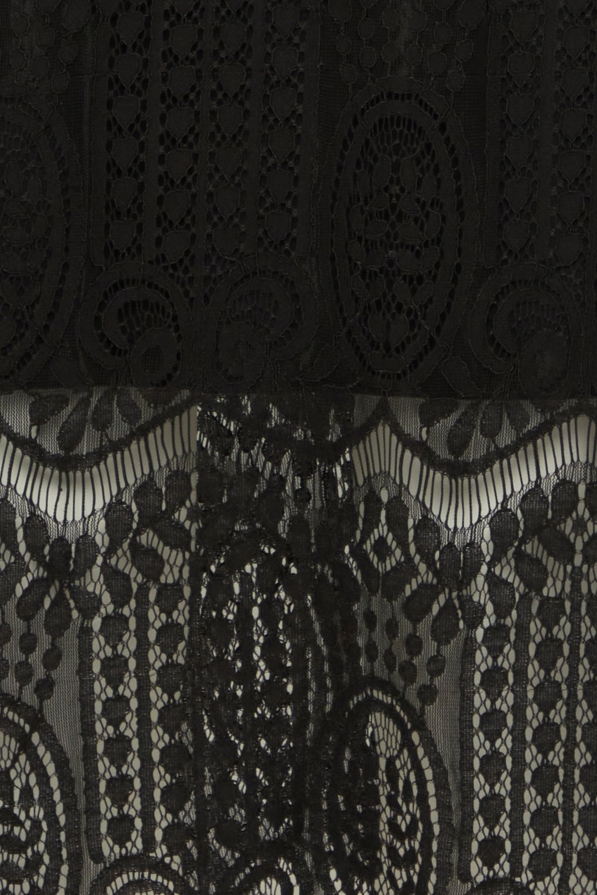 Black lace fabric with two distinct patterns; a top layer featuring repeating heart and oval motifs, and a bottom layer