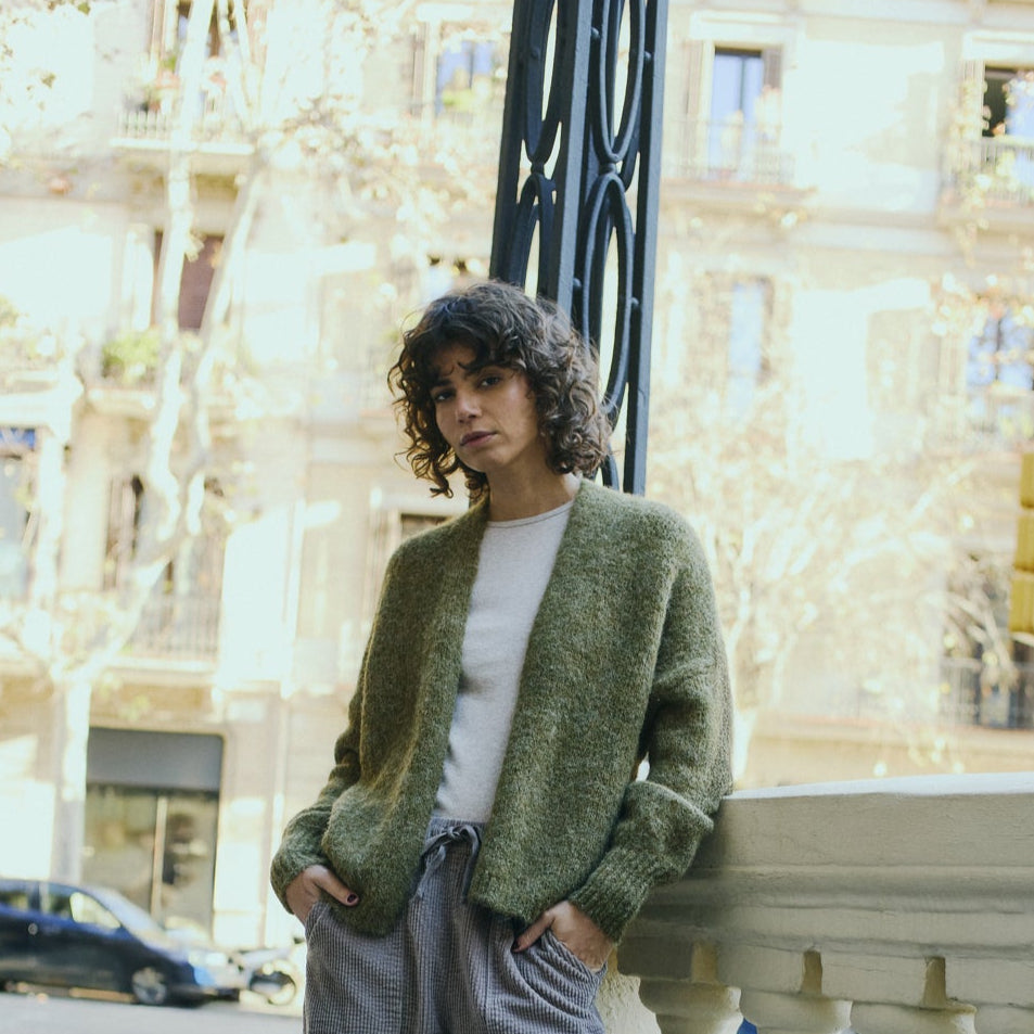 Woman wearing a green cardigan in an urban setting