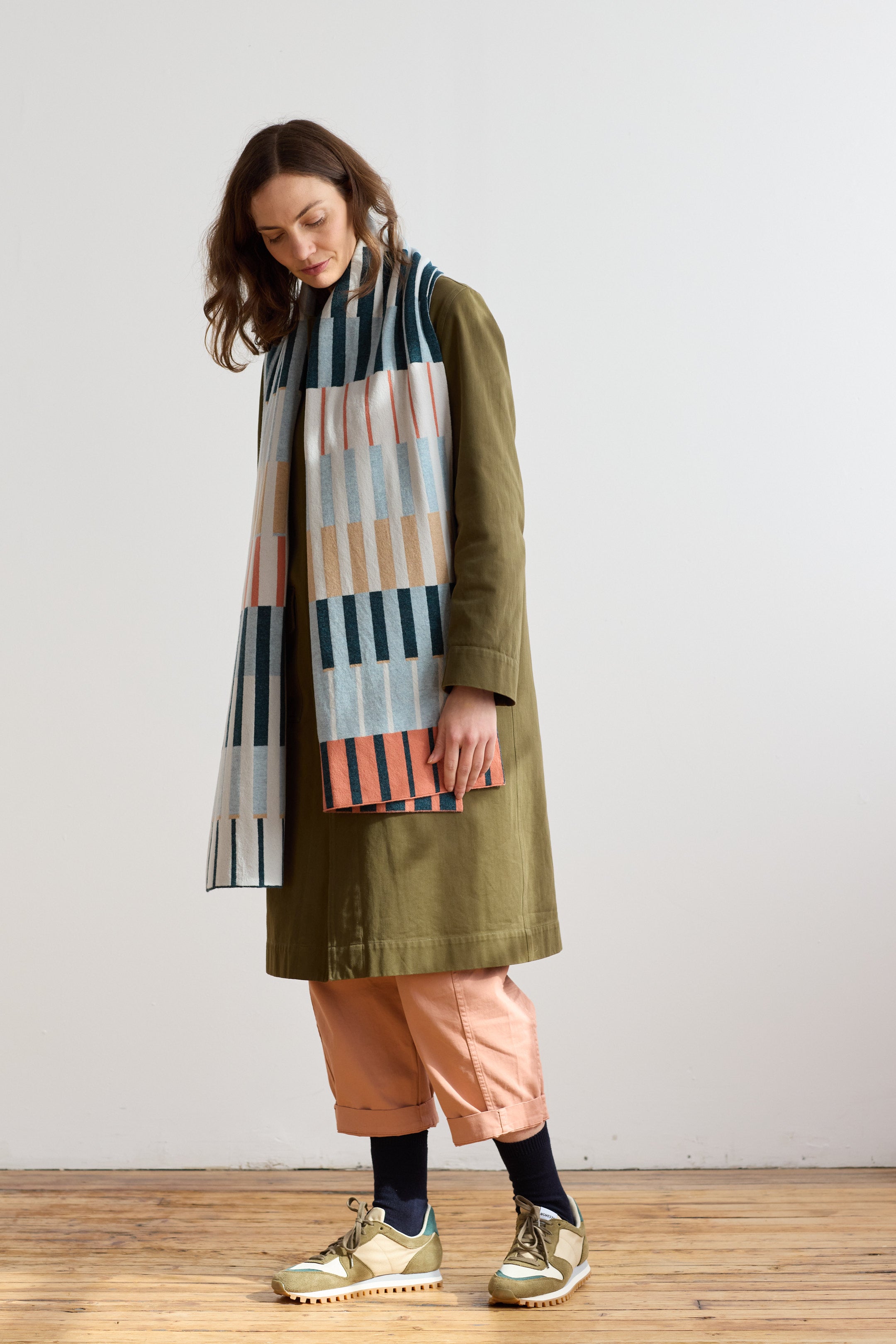 Abstract geometric patterned scarf in teal, light blue, beige, and coral.