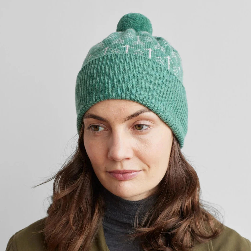 Seafoam green ribbed knit beanie with a pompom and subtle fair isle pattern.