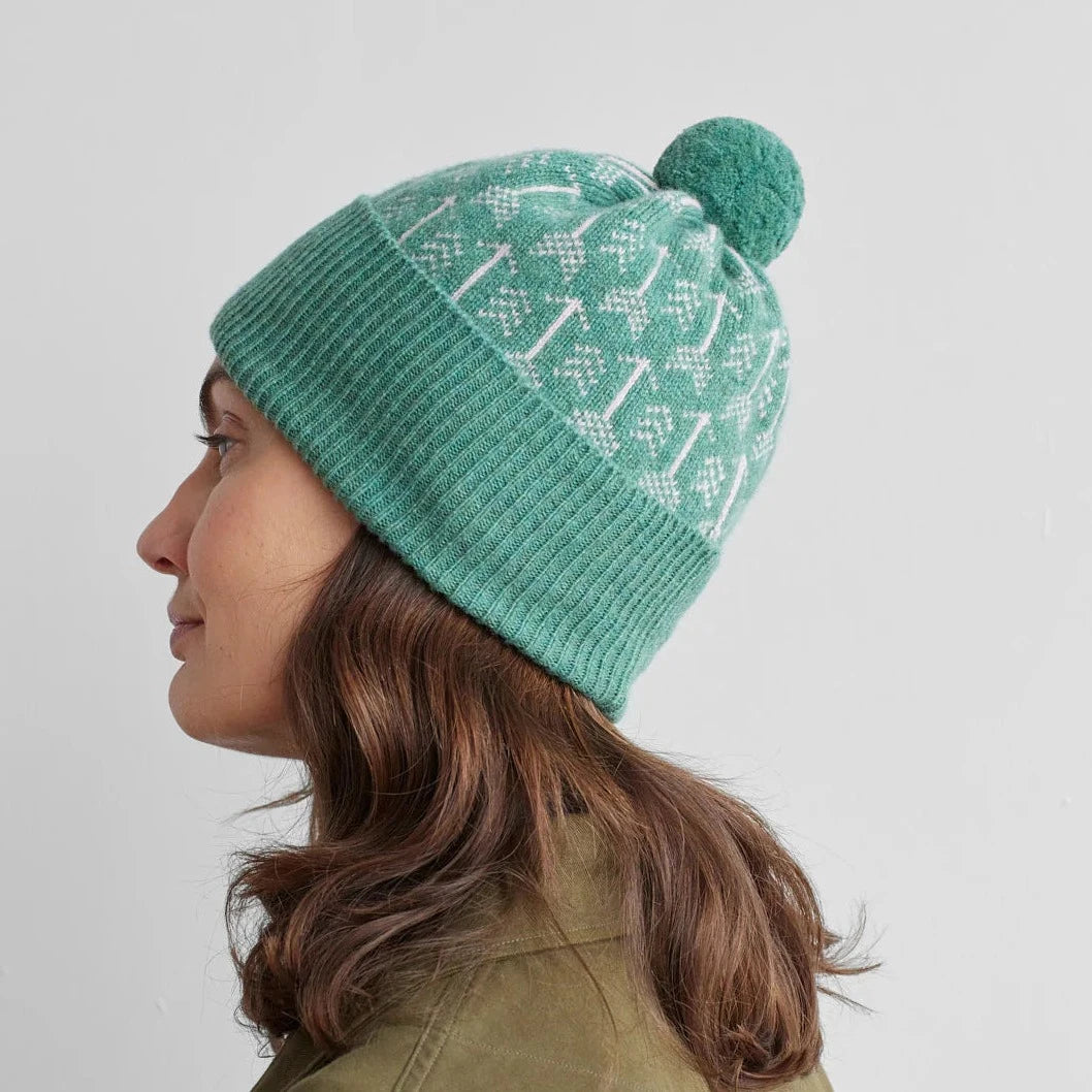 Teal knit beanie with white Fair Isle-style pattern and pompom.