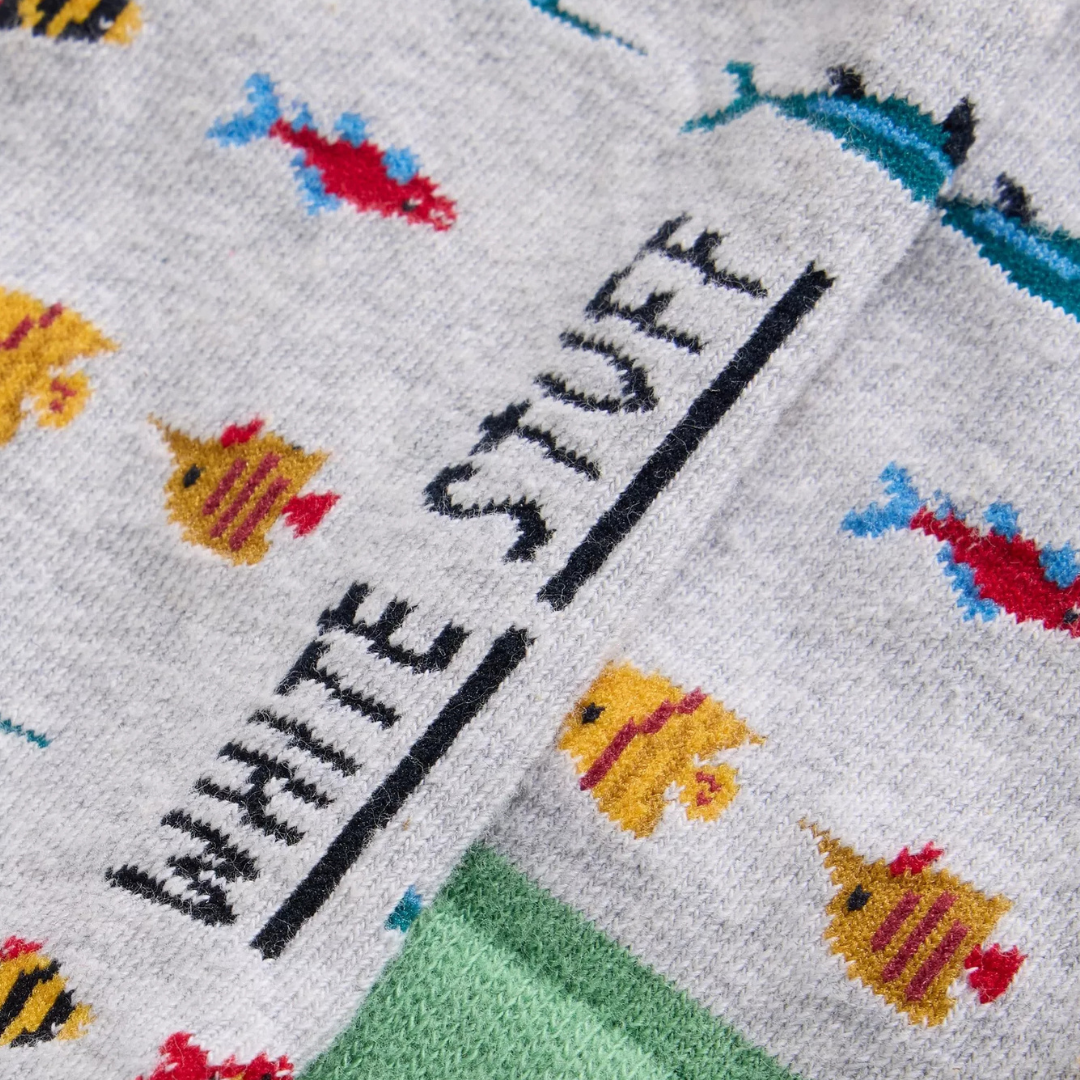 Grey socks with a colorful fish pattern and "White Stuff" logo knit into the fabric.