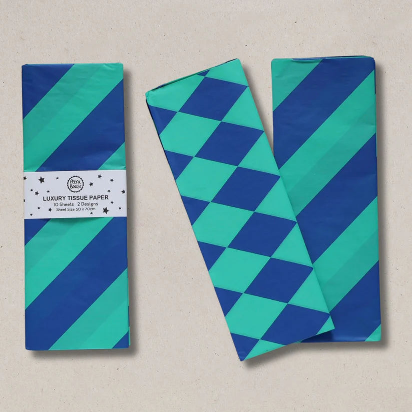 Two pieces of blue and green patterned tissue paper on a beige background