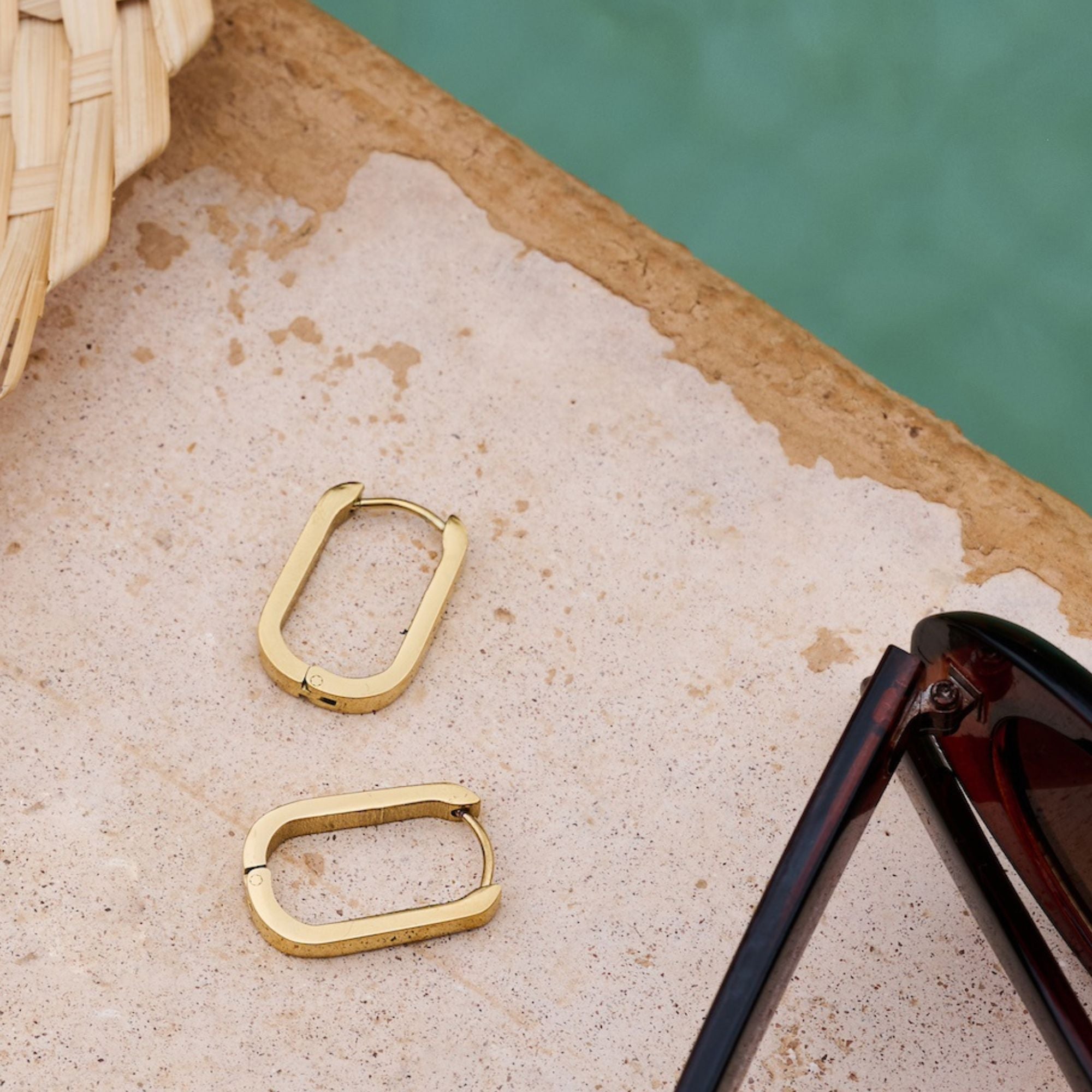 Pair of gold rectangular hoop earrings.