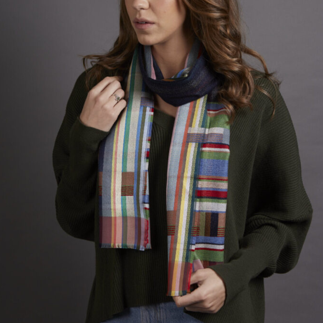 Multicolored striped and geometric patterned scarf. Features various shades of blue, green, red, and yellow.