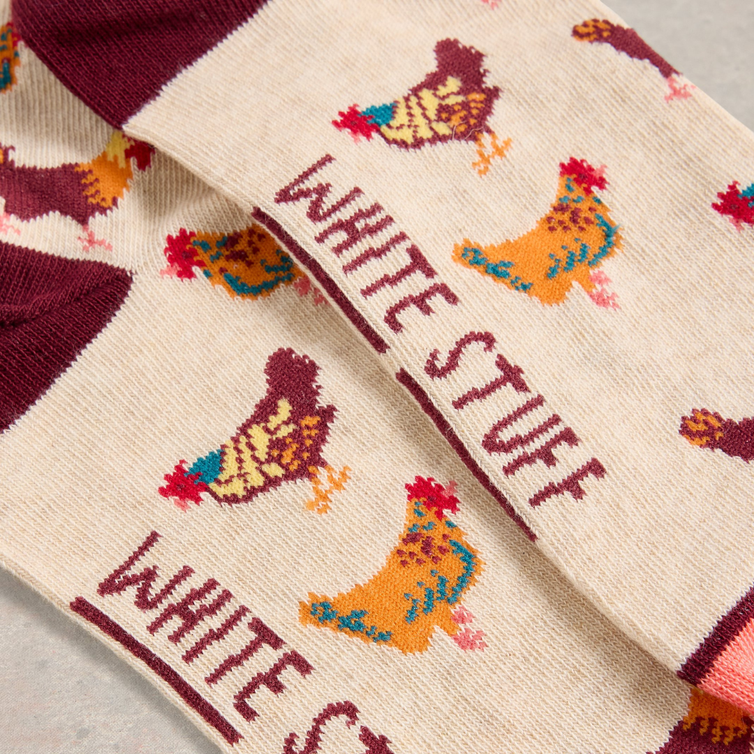 Cream-colored socks with maroon cuffs, featuring a repeating pattern of colorful chickens and the words "White Stuff"