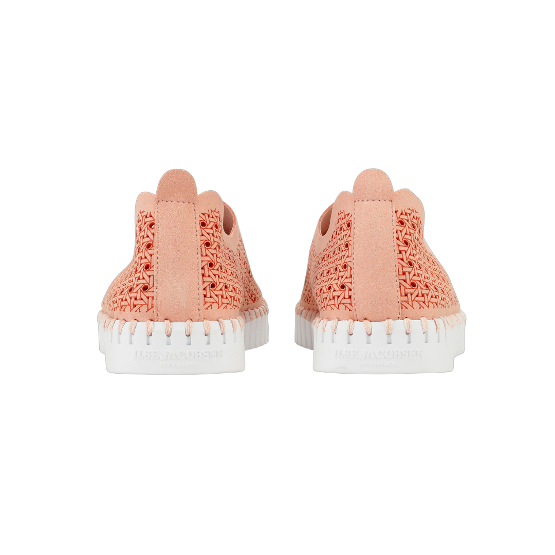 Pair of coral-pink Uske Jacobsen woven slip-on sneakers with white soles and stitching detail.