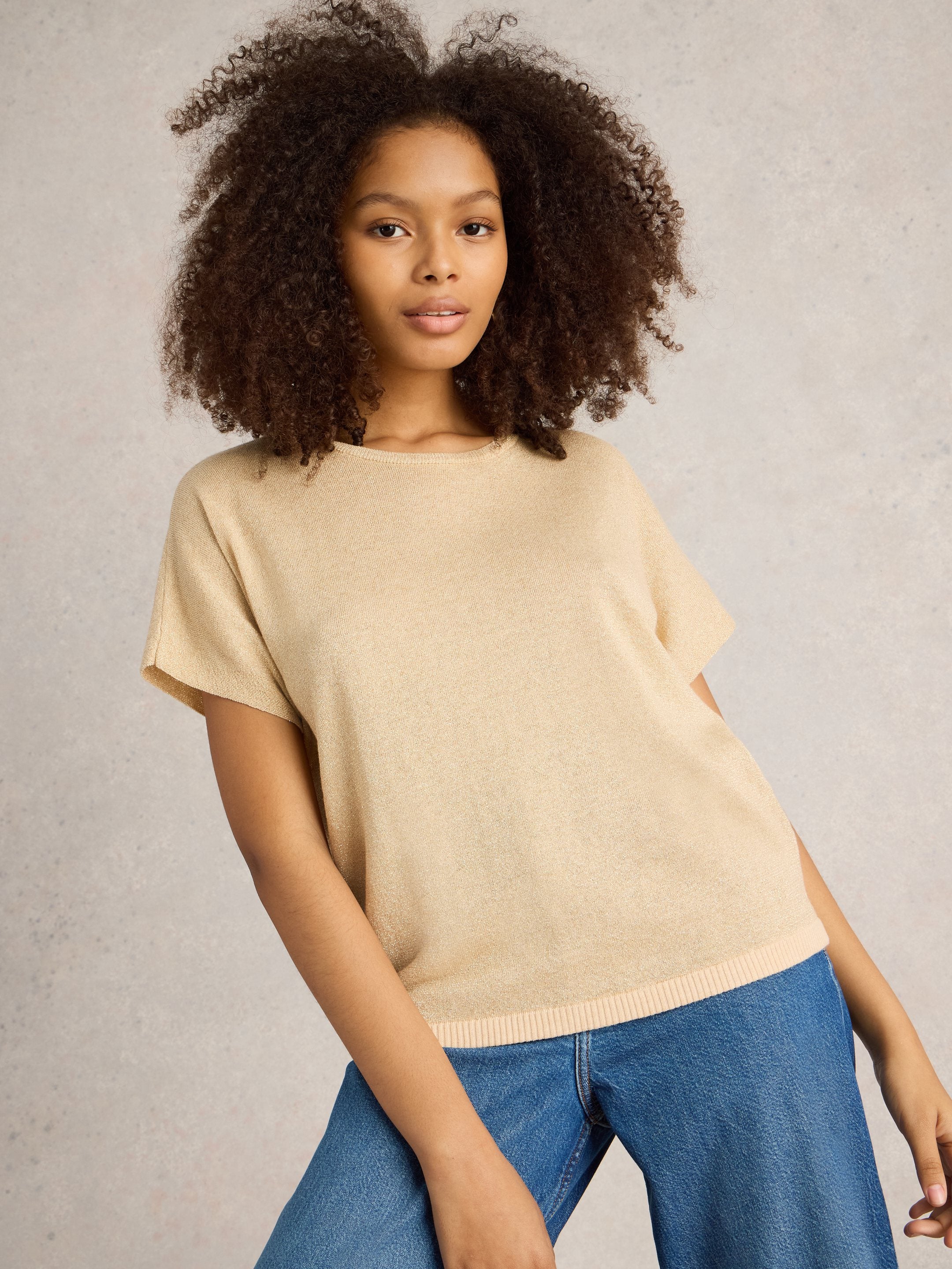 Beige short-sleeved knit top with a subtle shimmer, featuring a relaxed fit and round neckline.