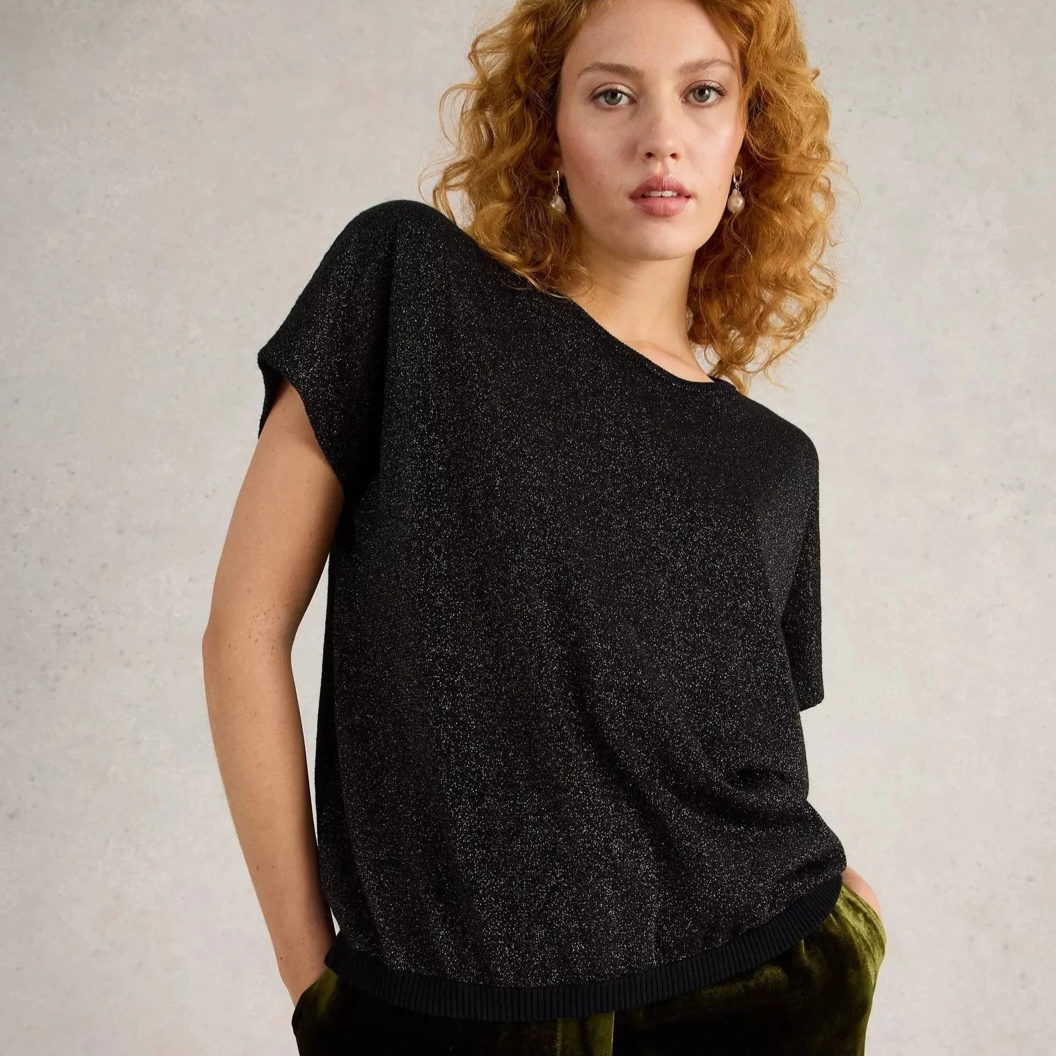 Black glitter short-sleeved knit top with a round neckline.