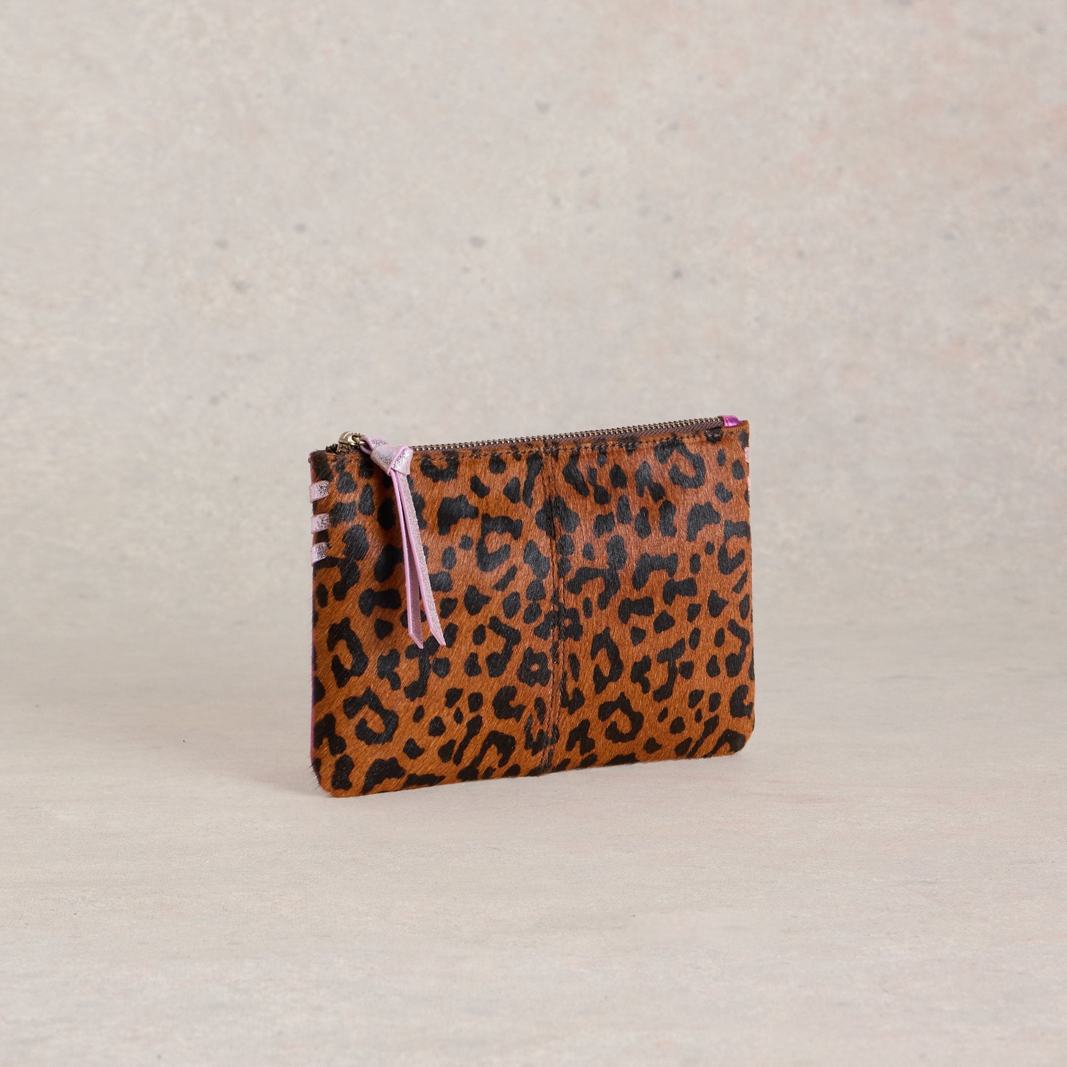 Brown and black leopard print calf hair pouch with a purple zipper pull.