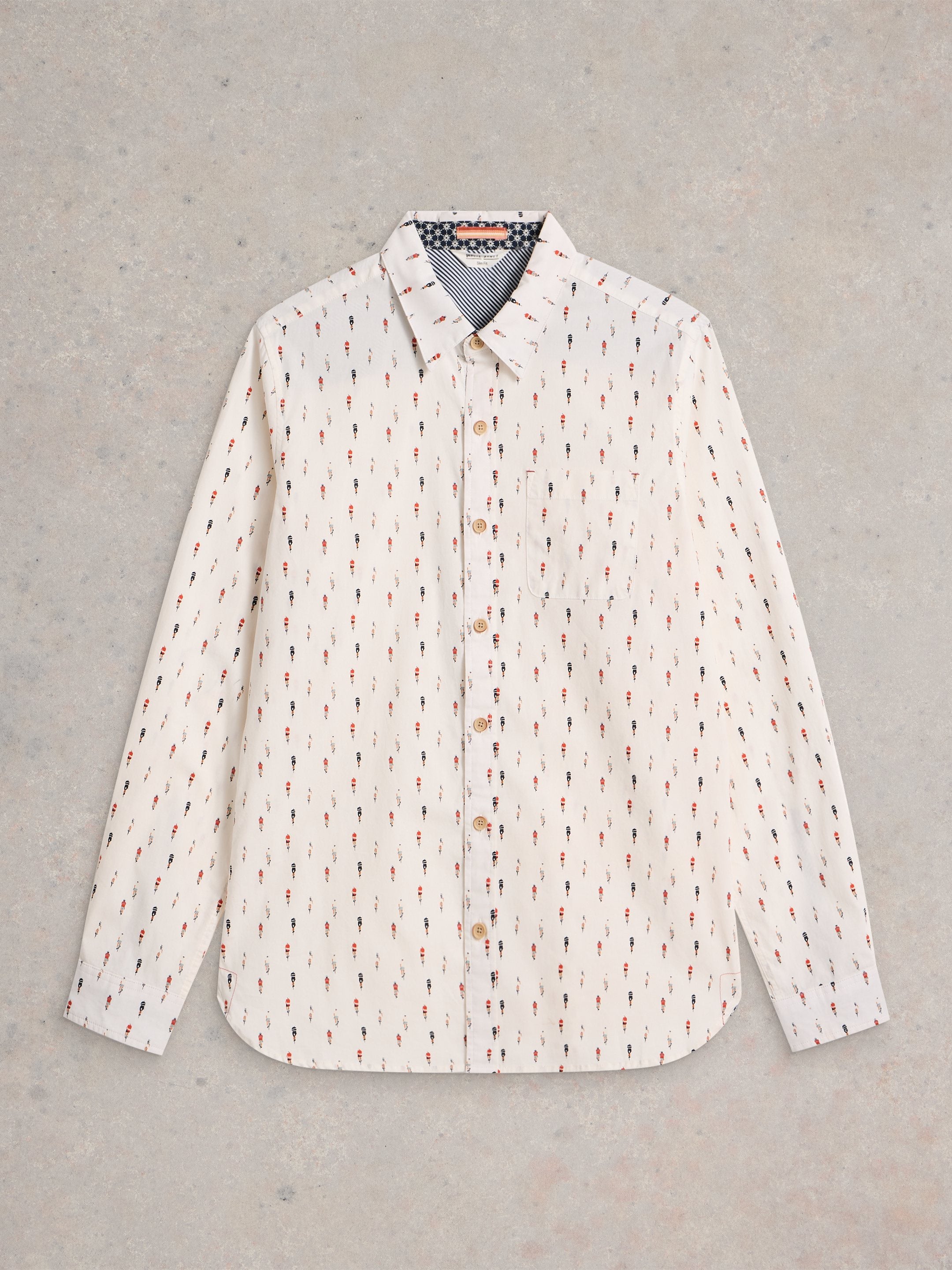 Off-white long-sleeve button-down shirt with a repeating pattern of small, stylized figures in red, black, and blue.