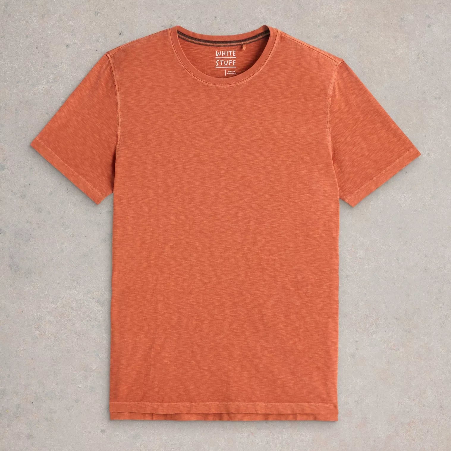 Burnt orange short-sleeve crew neck t-shirt, featuring a slightly textured fabric. White Stuff brand label visible.
