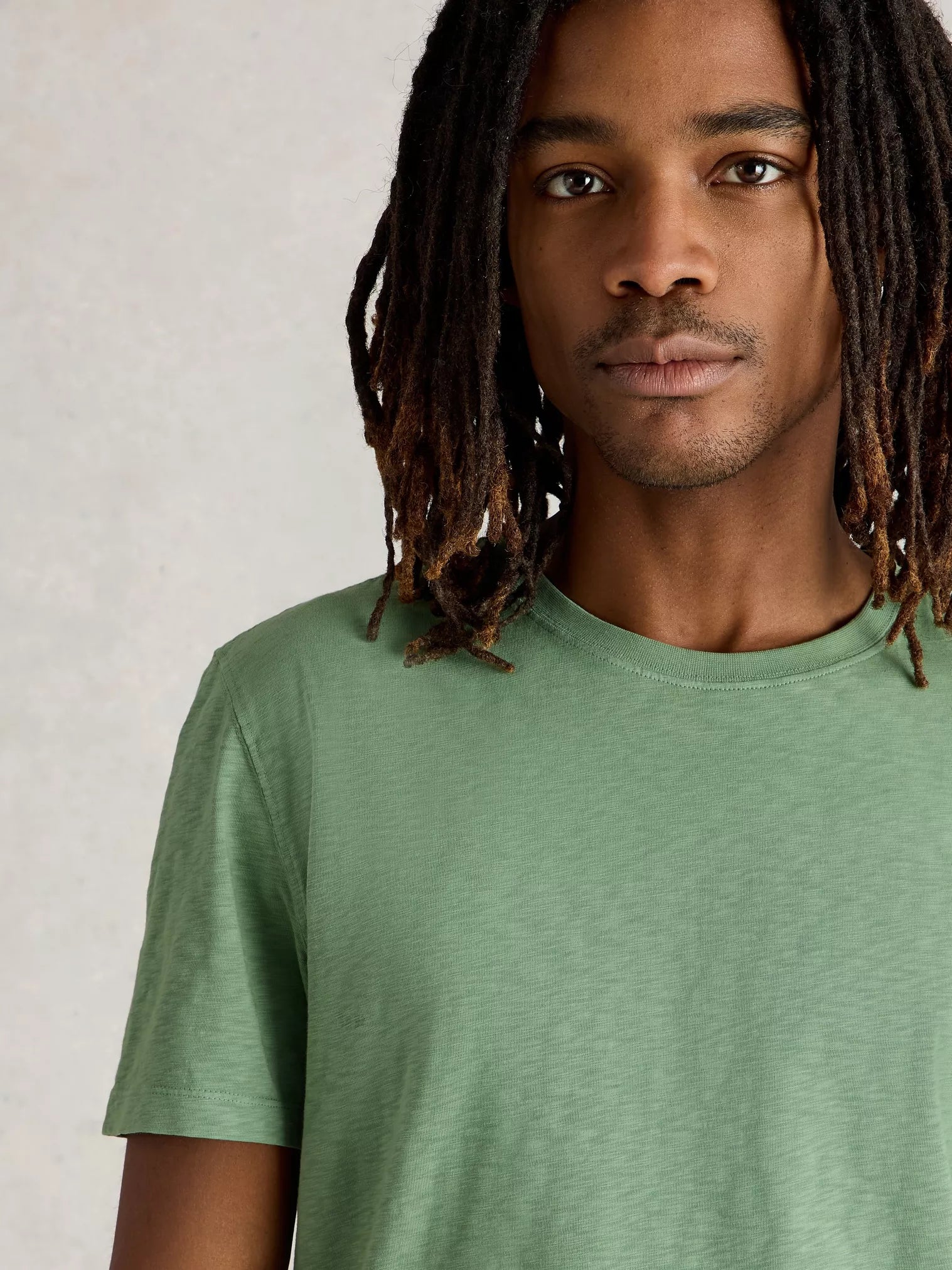 Sage green short-sleeve crew neck t-shirt with a slightly textured fabric.
