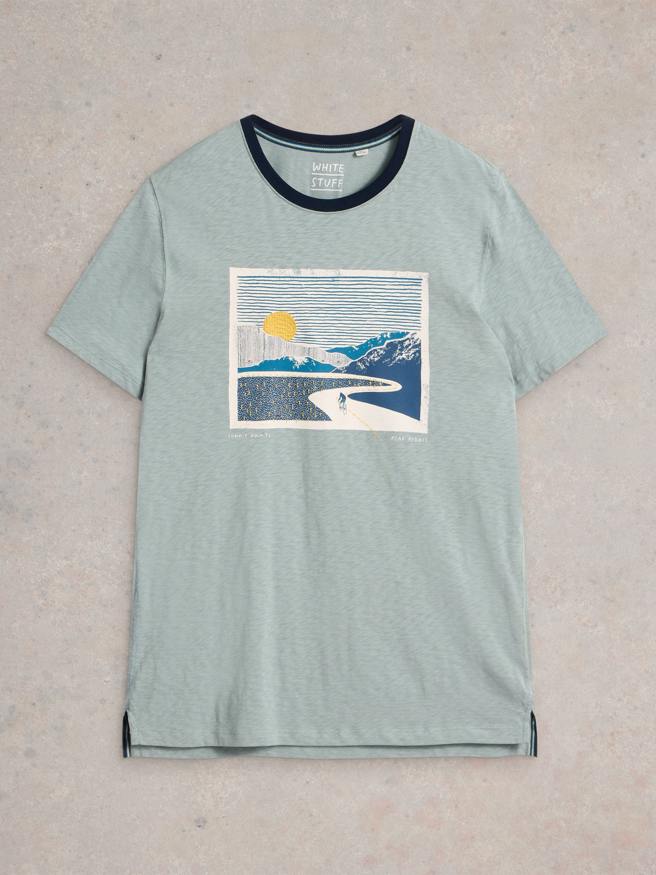 Sage green t-shirt with a navy trim and a central graphic depicting a cyclist on a winding road leading to mountains under a