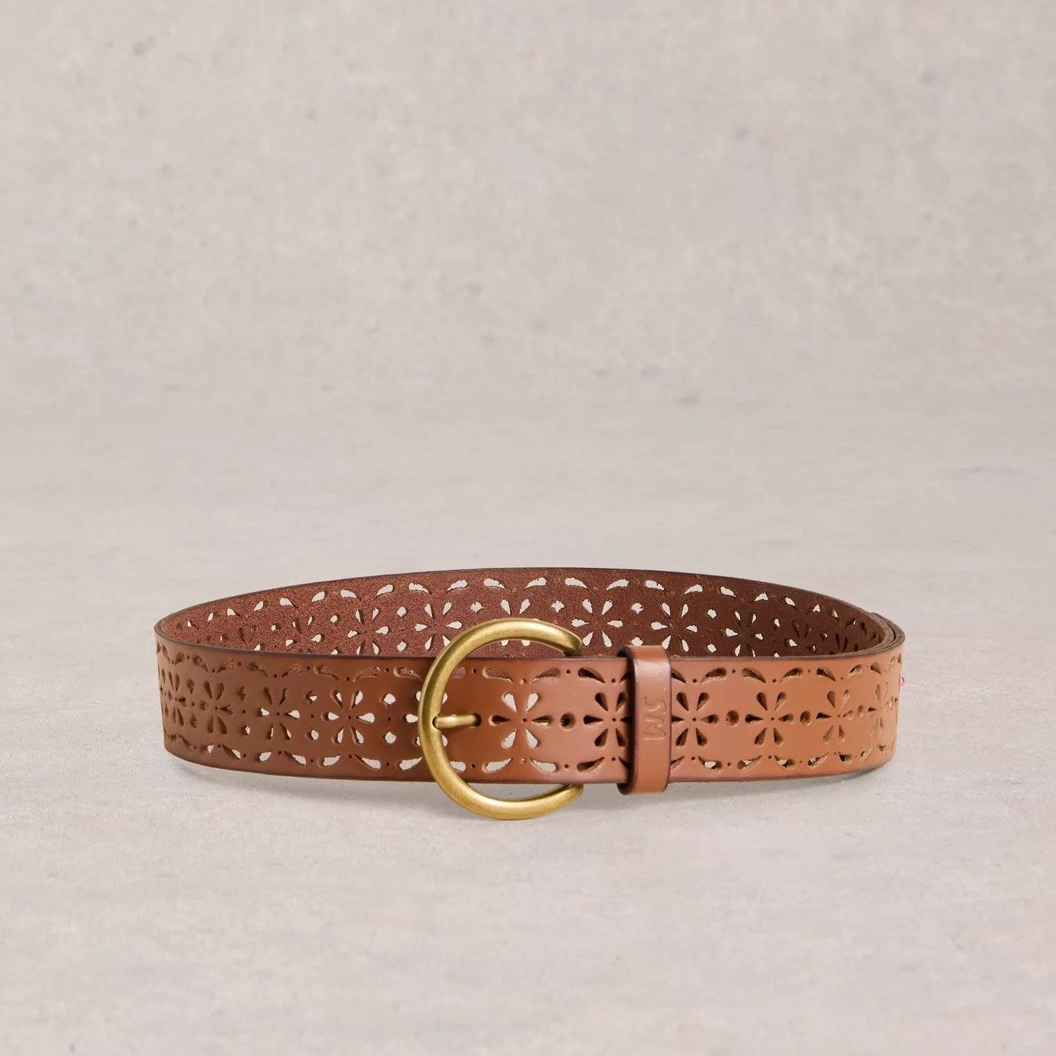 Brown leather belt with gold buckle on a beige background