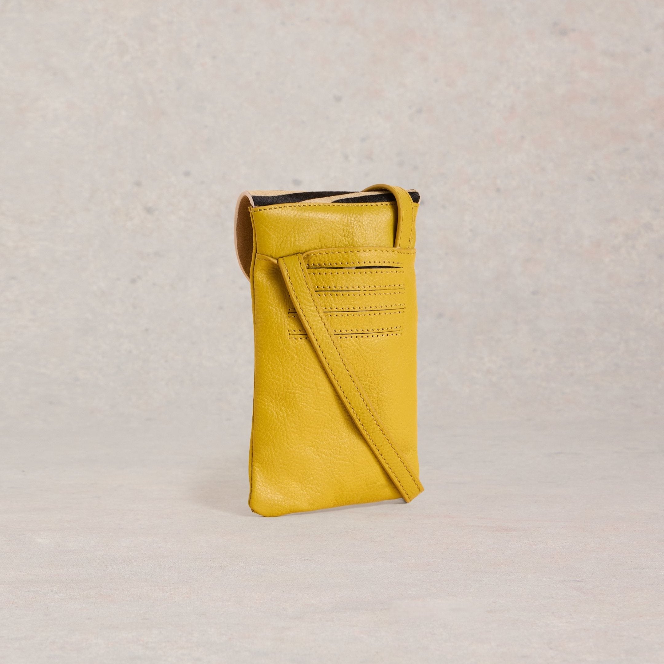 Mustard yellow leather crossbody phone bag with a subtle textured surface and stitched detailing.