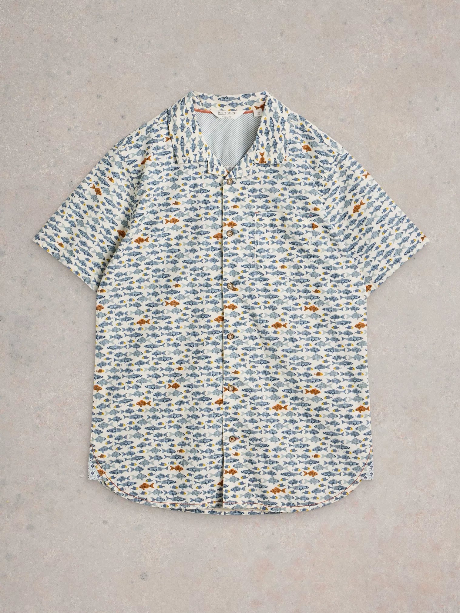 Short-sleeved button-down shirt with an all-over print of small blue and orange fish on a cream background.