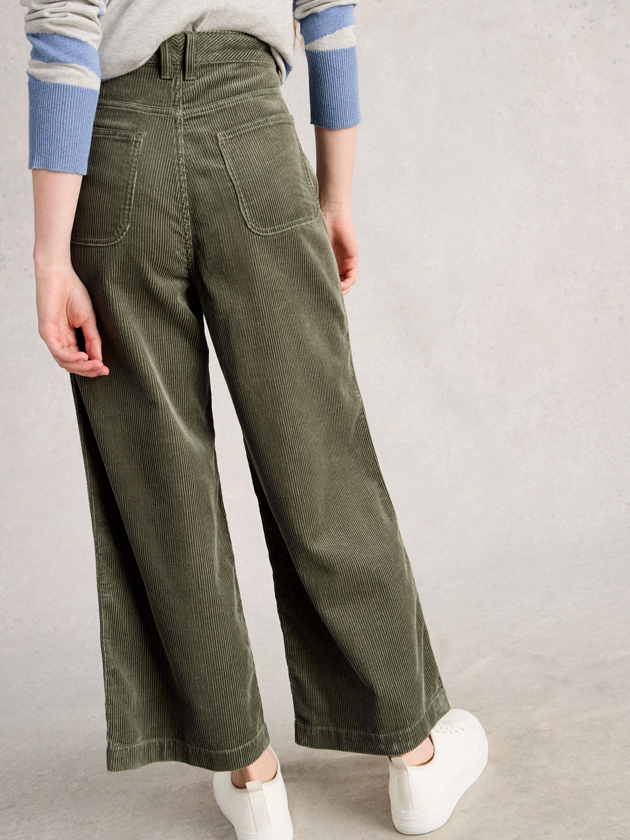 Person wearing green wide-leg pants on a plain background