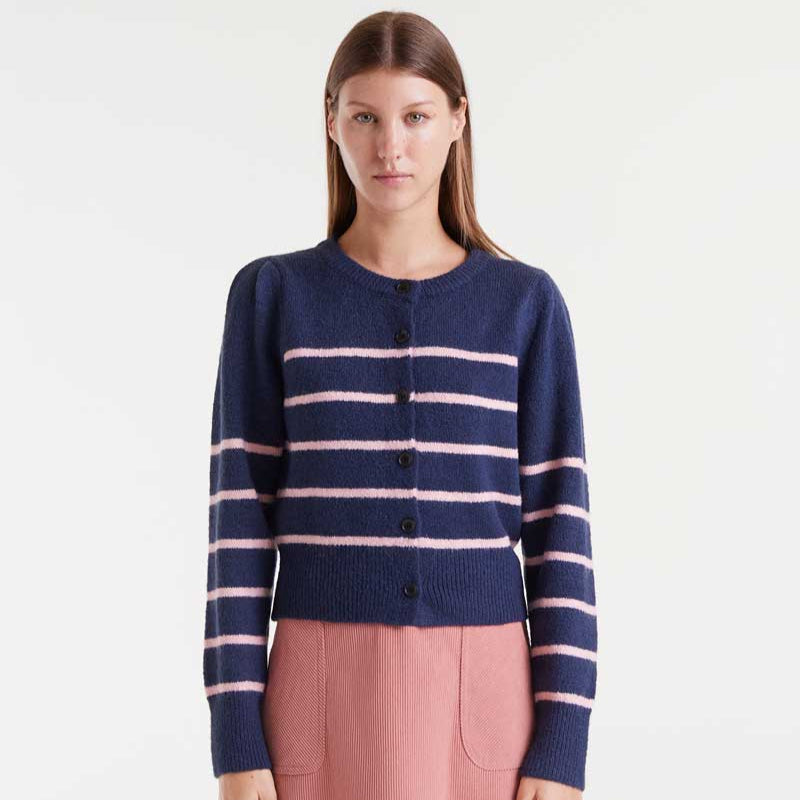 Woman wearing a navy blue cardigan with pink stripes on a white background