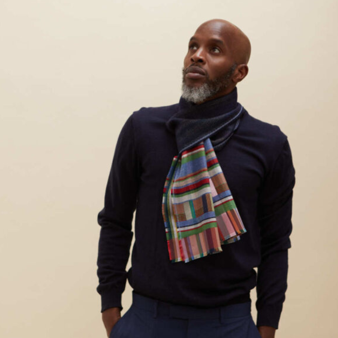 Multicolored striped wool scarf with a dark navy base, displayed around the neck of a model.