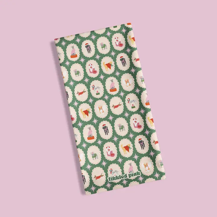 Green fabric with a repeating pattern of dogs in Christmas attire within decorative frames and stars.