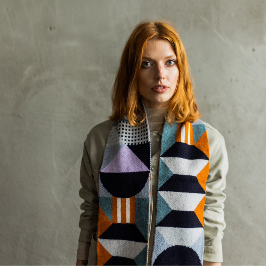 Geometric patterned wool scarf in teal, purple, orange, and black.