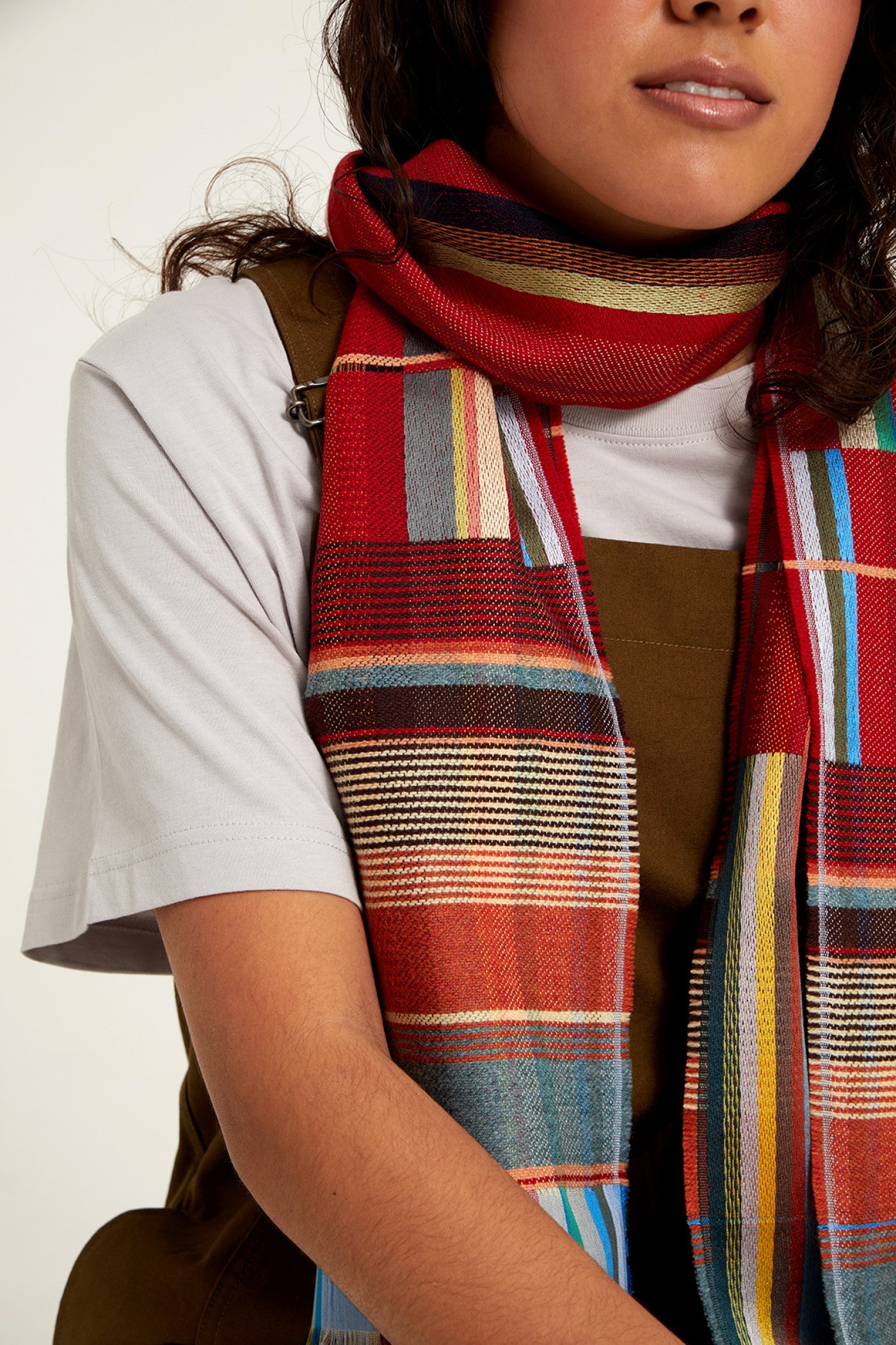 Red, multicolored striped woven scarf with teal, beige, and yellow accents.