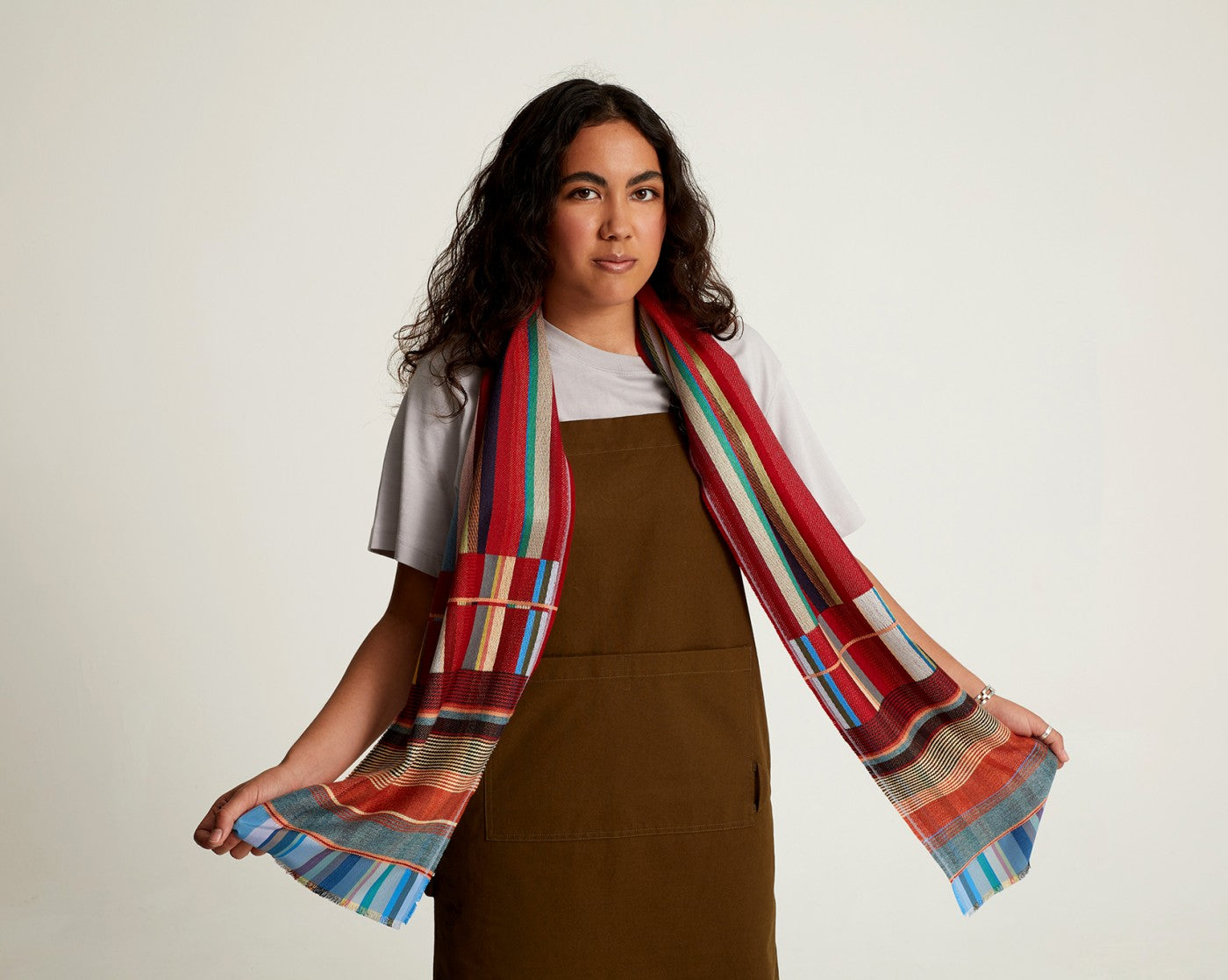 Multicolored striped and patterned scarf draped around a person's neck.