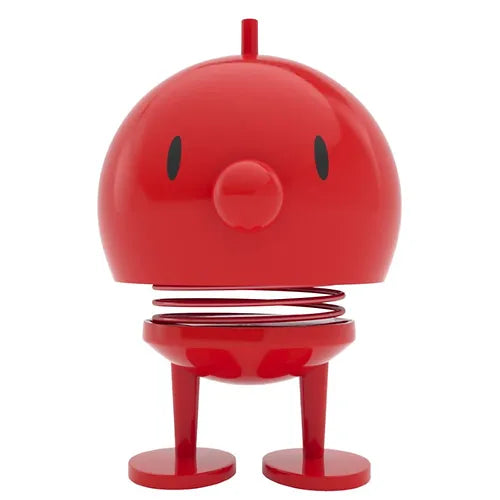 Red bobblehead toy with a spring, simple face, and short legs.