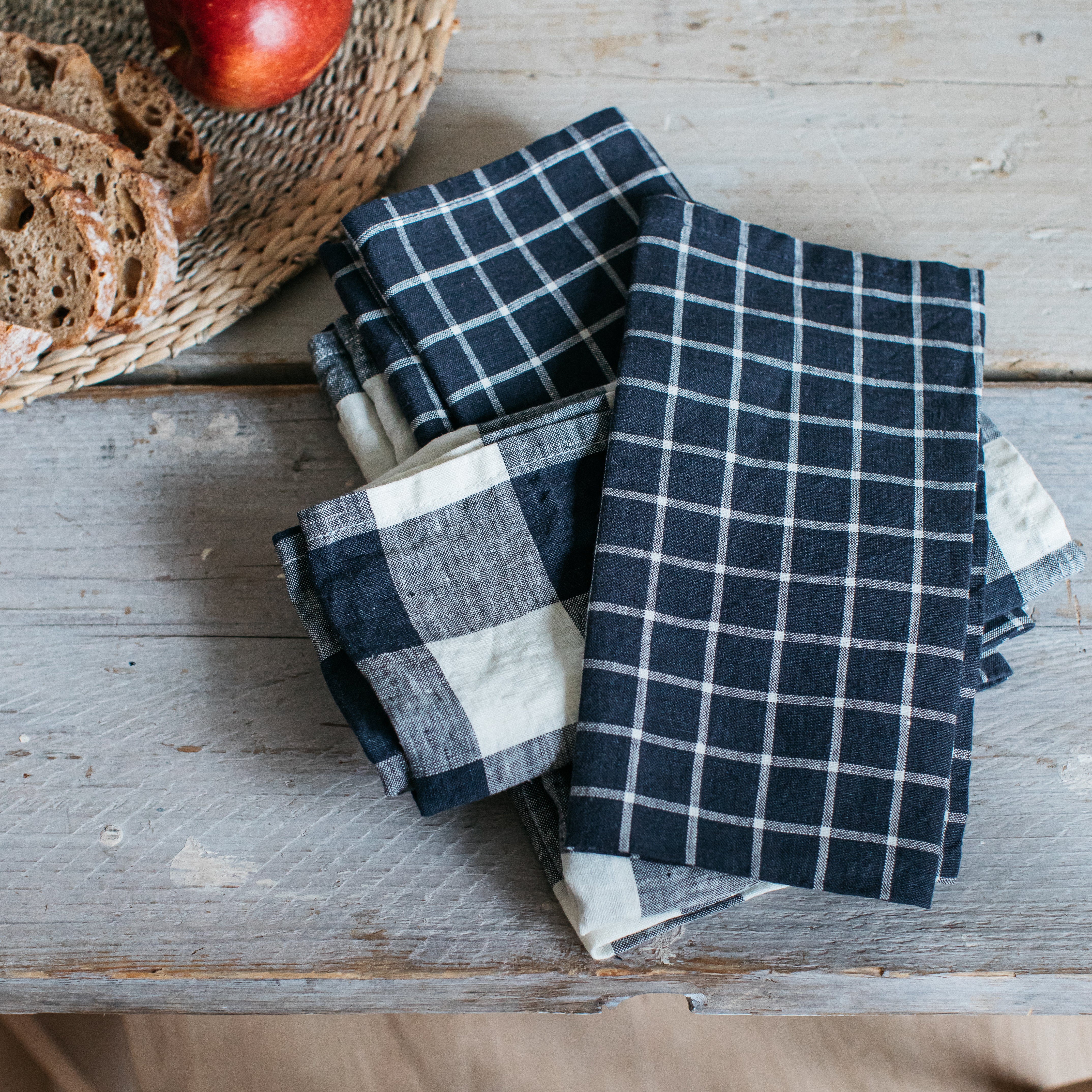 Stack of linen napkins in navy blue and off-white gingham patterns.