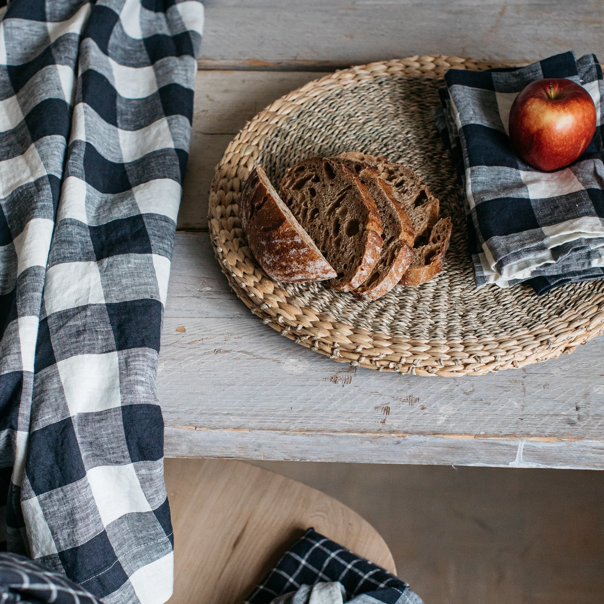 Several slices of dark bread arranged on a round woven placemat.