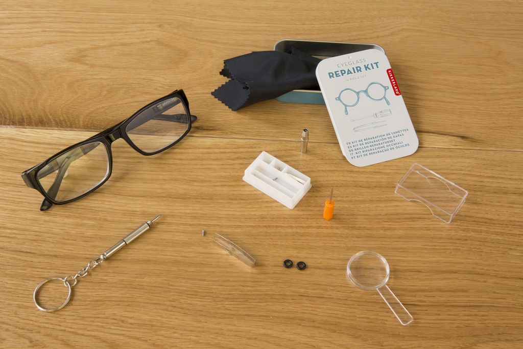 Eyeglass repair kit with tools in a tin, including a screwdriver, tweezers, and small parts.