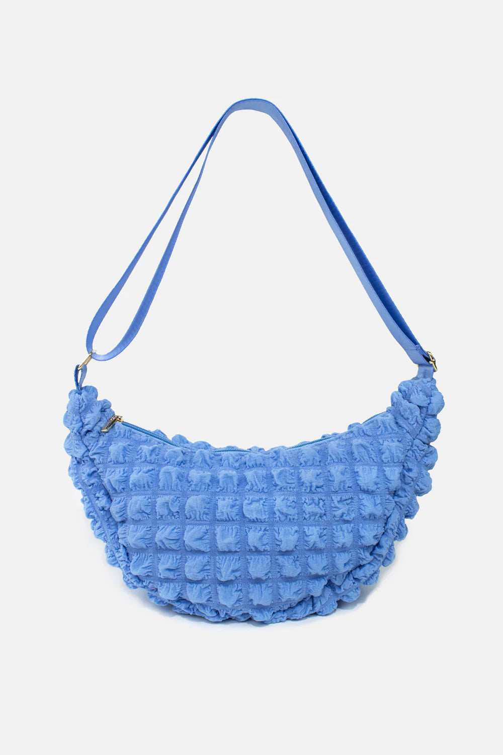 Blue crescent-shaped crossbody bag with a textured, quilted pattern.