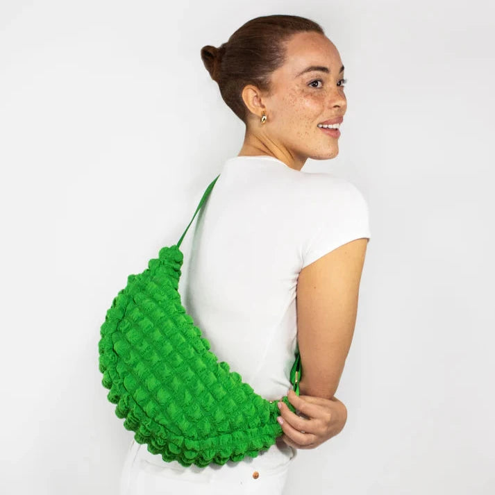 Bright green textured half-moon crossbody bag with a puffy, quilted design.