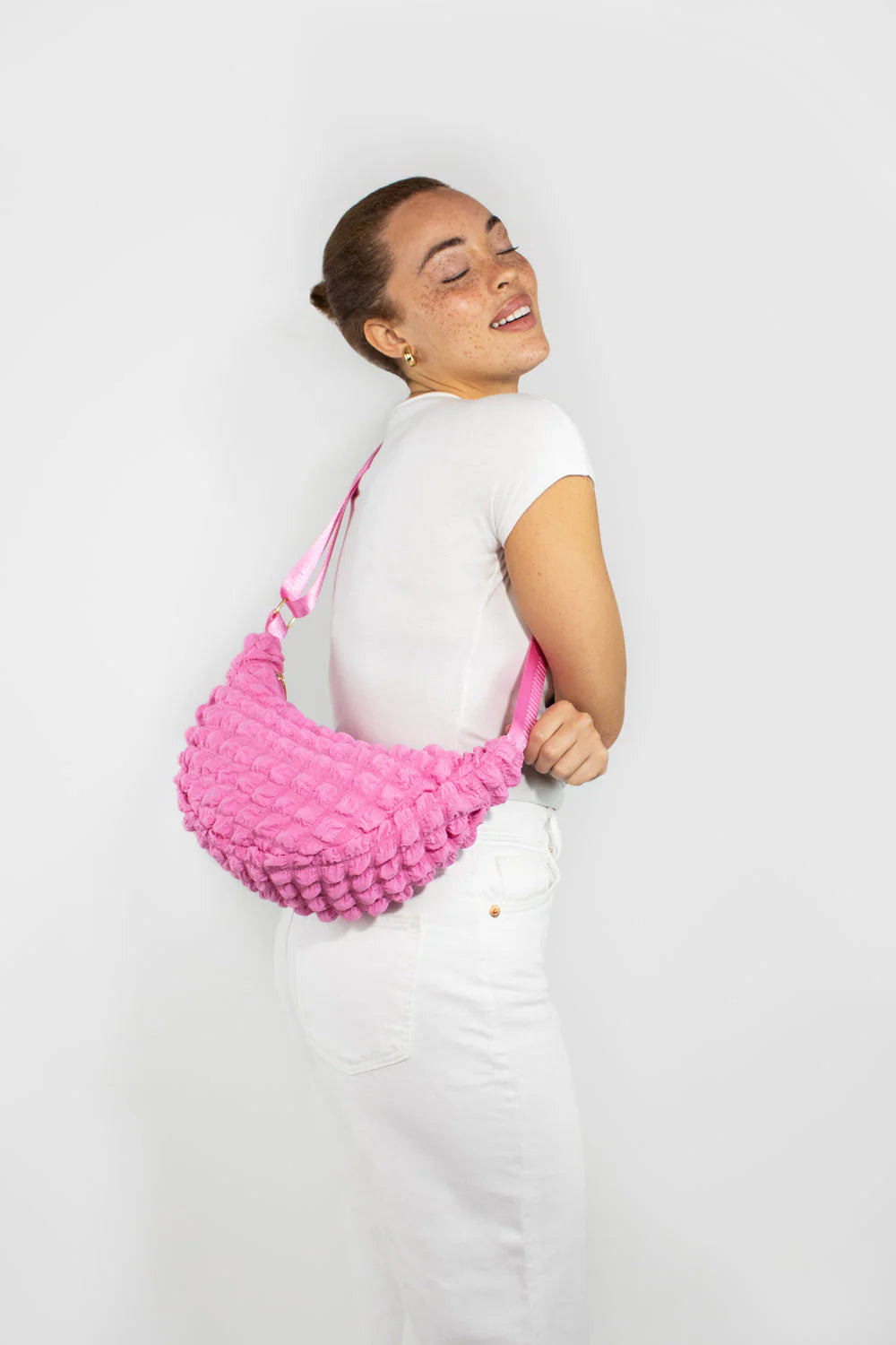Pink textured fabric fanny pack with a light pink strap.